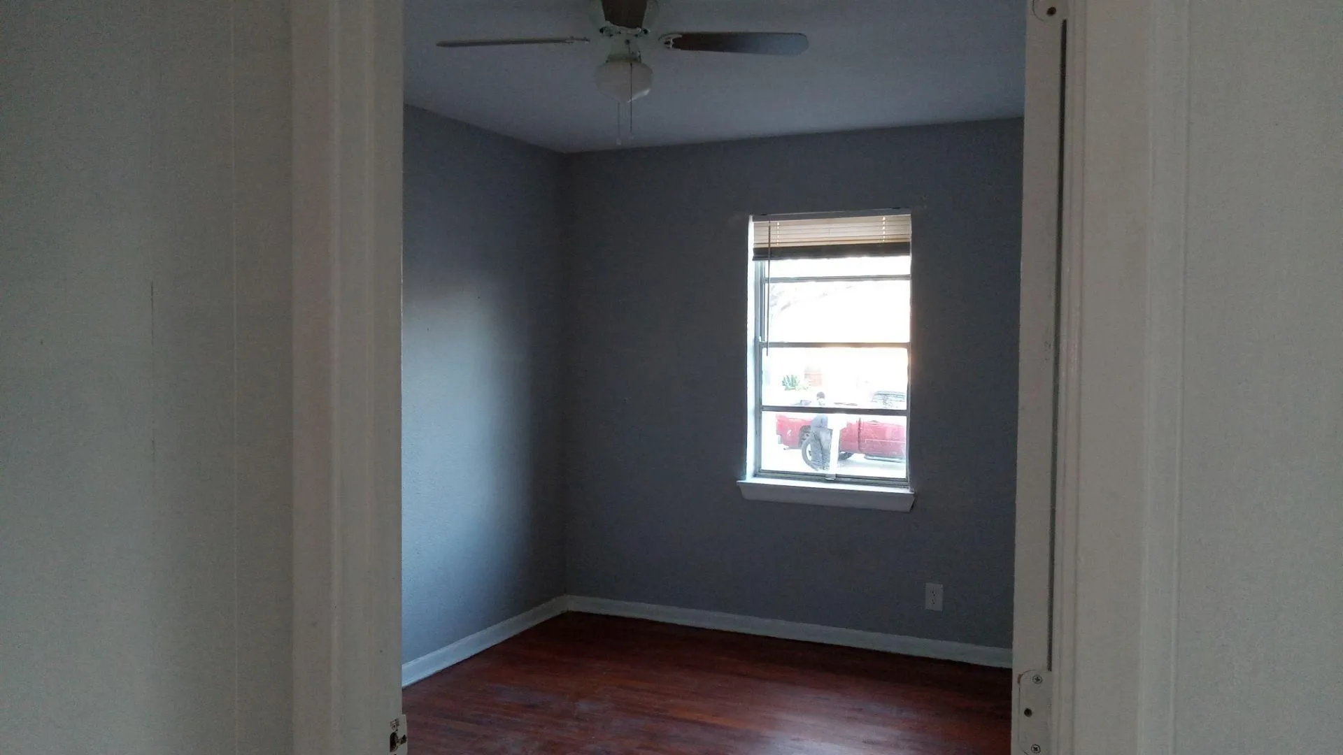 Unfurnished room with dark wood-style floors and ceiling fan