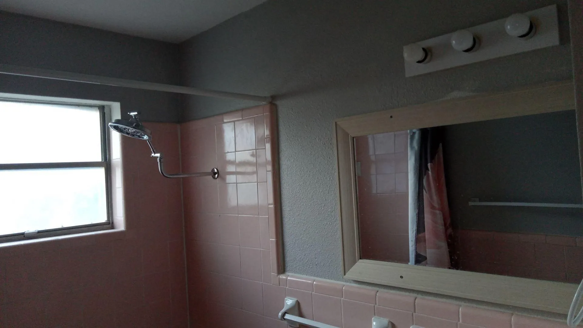 Bathroom with tiled shower and a textured wall