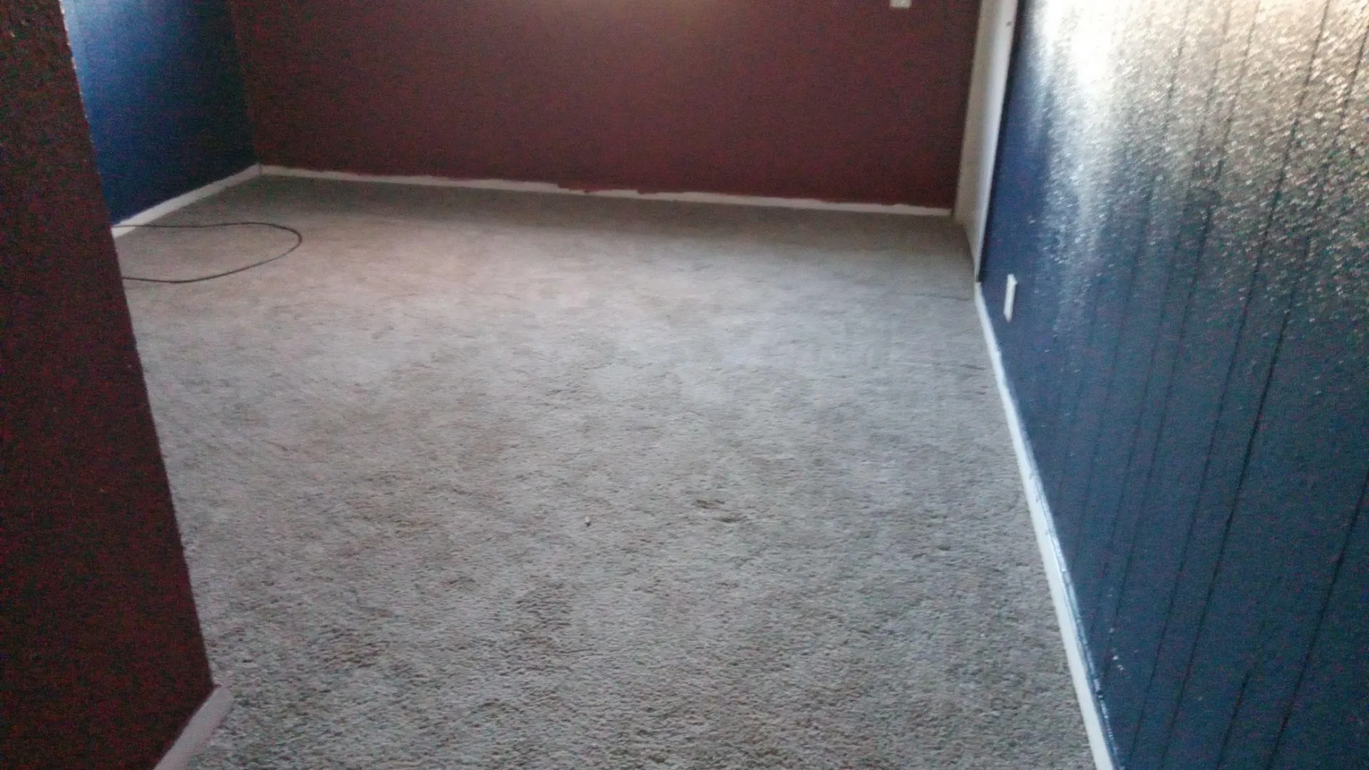 Empty room featuring light colored carpet and baseboards