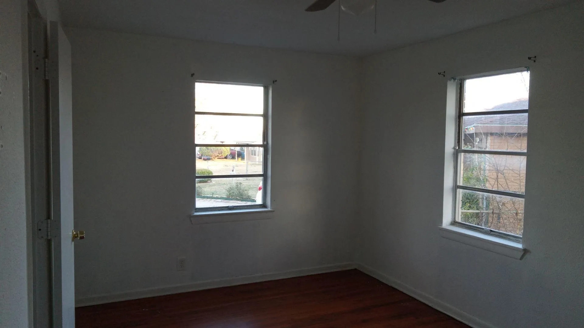 Spare room featuring dark wood-type flooring and a ceiling fan