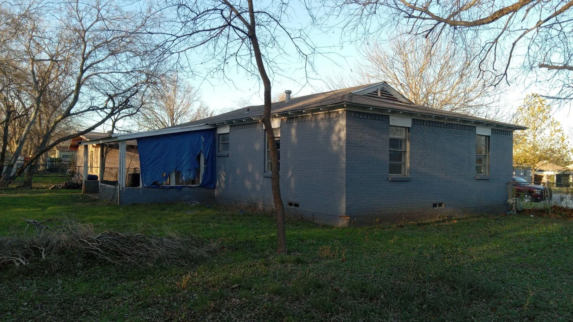 View of property exterior with crawl space, brick siding, and a yard