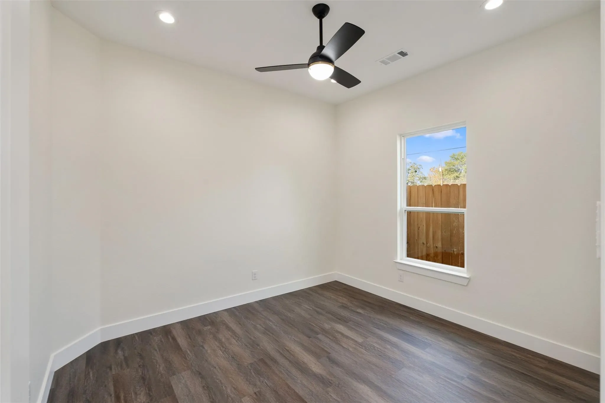 Empty room with recessed lighting, dark wood-style flooring, and ceiling fan