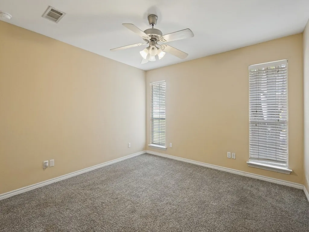 Primary bedroom with 2 windows letting in good natural light