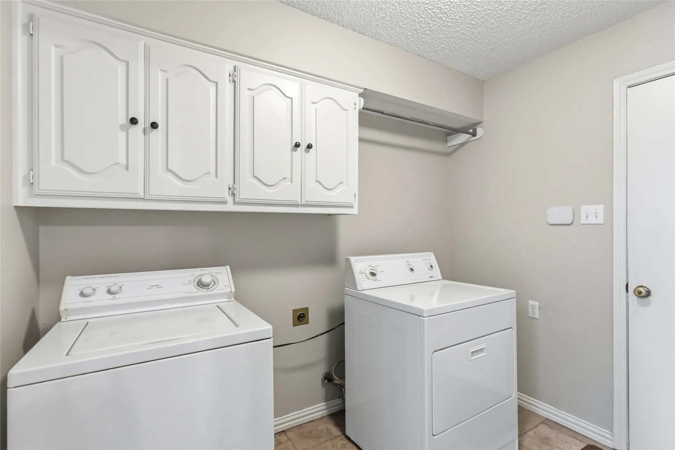 Utility room at 200 Sunny Crest Dr, Murphy TX in Timbers 3 with full-size washer and dryer connections and storage cabinets.