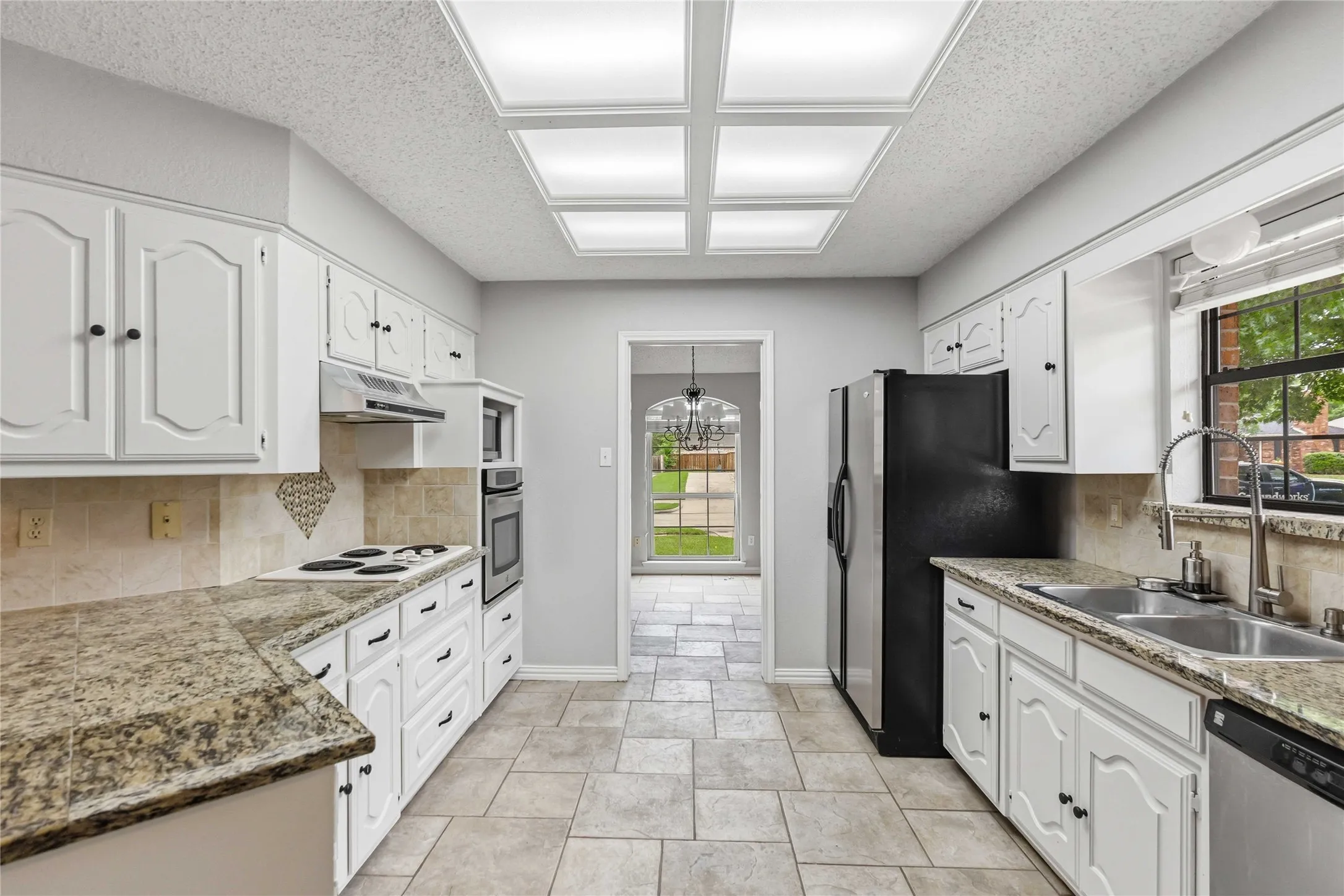 Functional kitchen layout at 200 Sunny Crest Dr, Murphy TX in the Timbers 3 community with tile flooring and natural light.