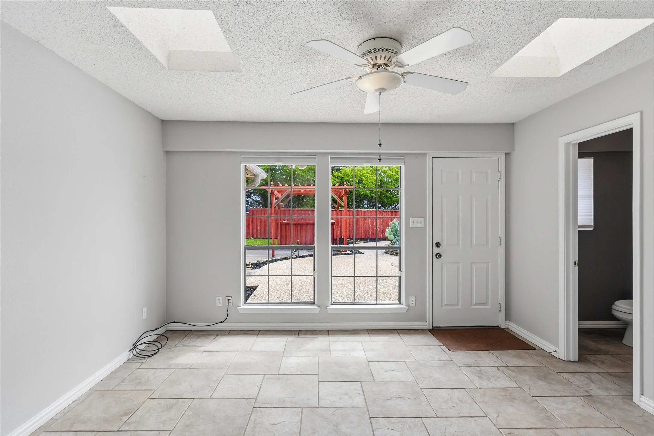 Living space with backyard views at 200 Sunny Crest Dr, Murphy TX in the Timbers 3 community featuring tile flooring and ceiling fan.