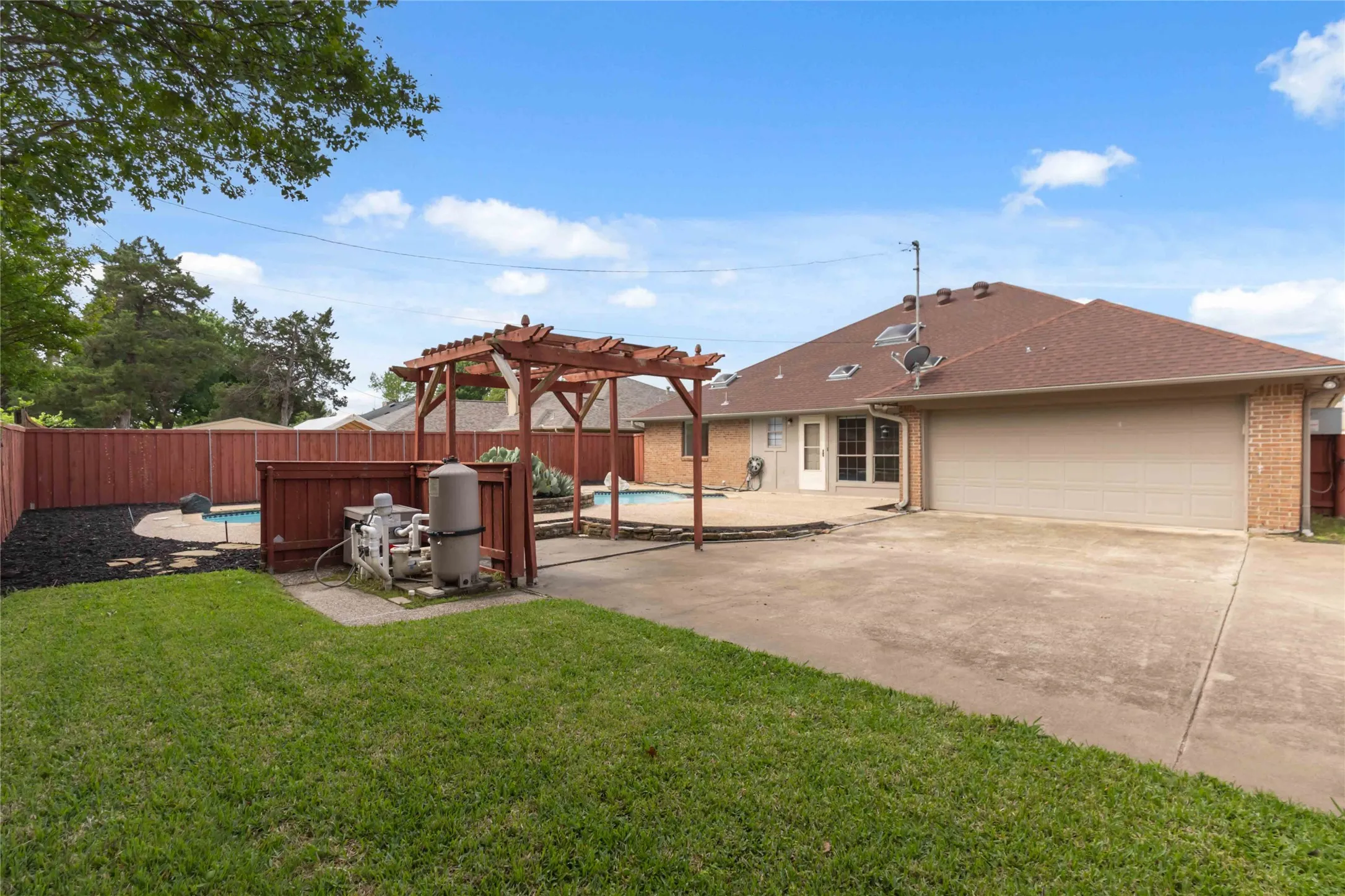 Backyard view at 200 Sunny Crest Dr, Murphy TX in the Timbers 3 community showcasing pool and fenced yard.