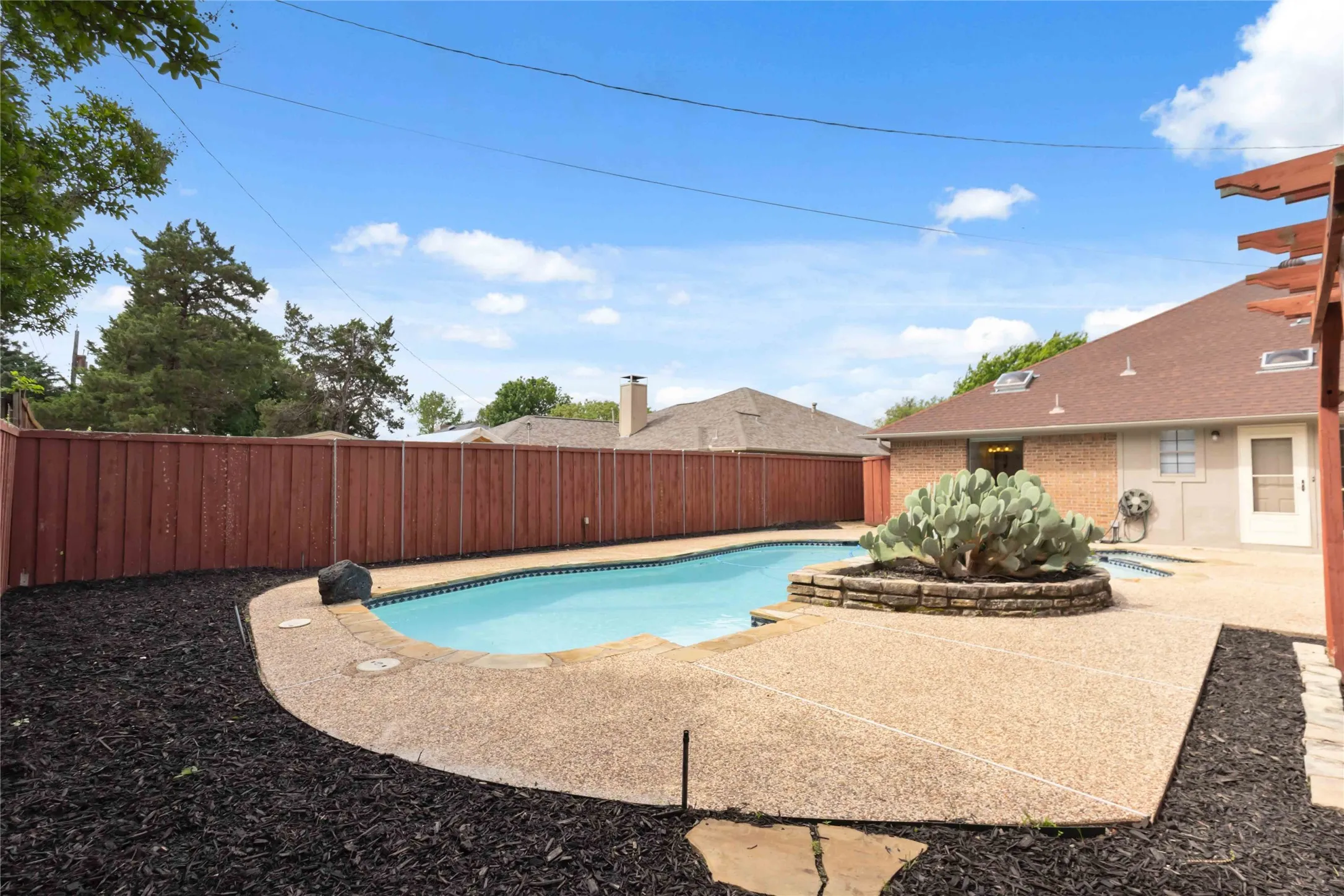 Backyard pool area at 200 Sunny Crest Dr, Murphy TX in the Timbers 3 community with privacy fencing and outdoor entertaining space.