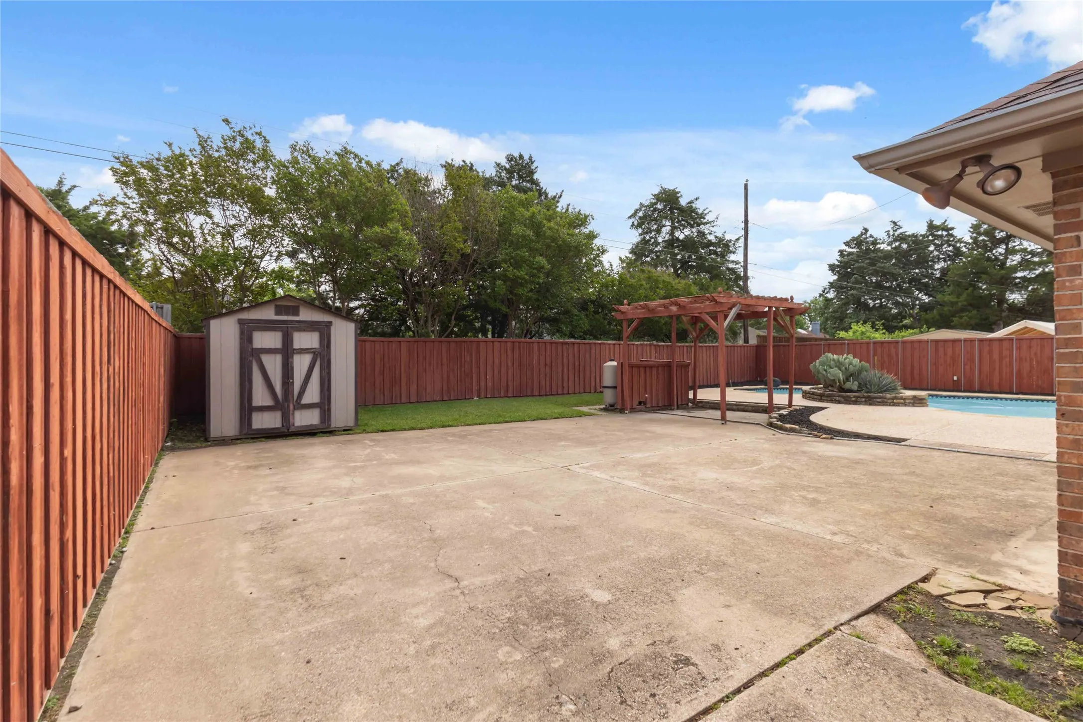 Backyard view at 200 Sunny Crest Dr, Murphy TX in the Timbers 3 community showcasing pool and fenced yard.