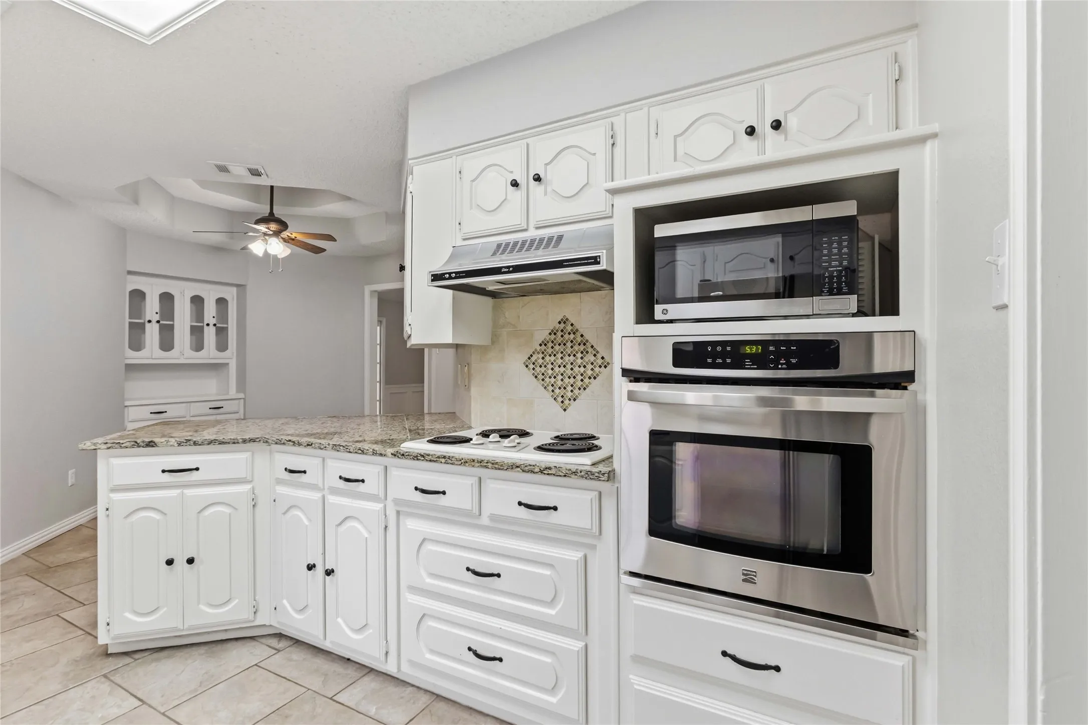 Updated kitchen at 200 Sunny Crest Dr, Murphy TX in the Timbers 3 community featuring granite countertops, white cabinetry, and ample storage.
