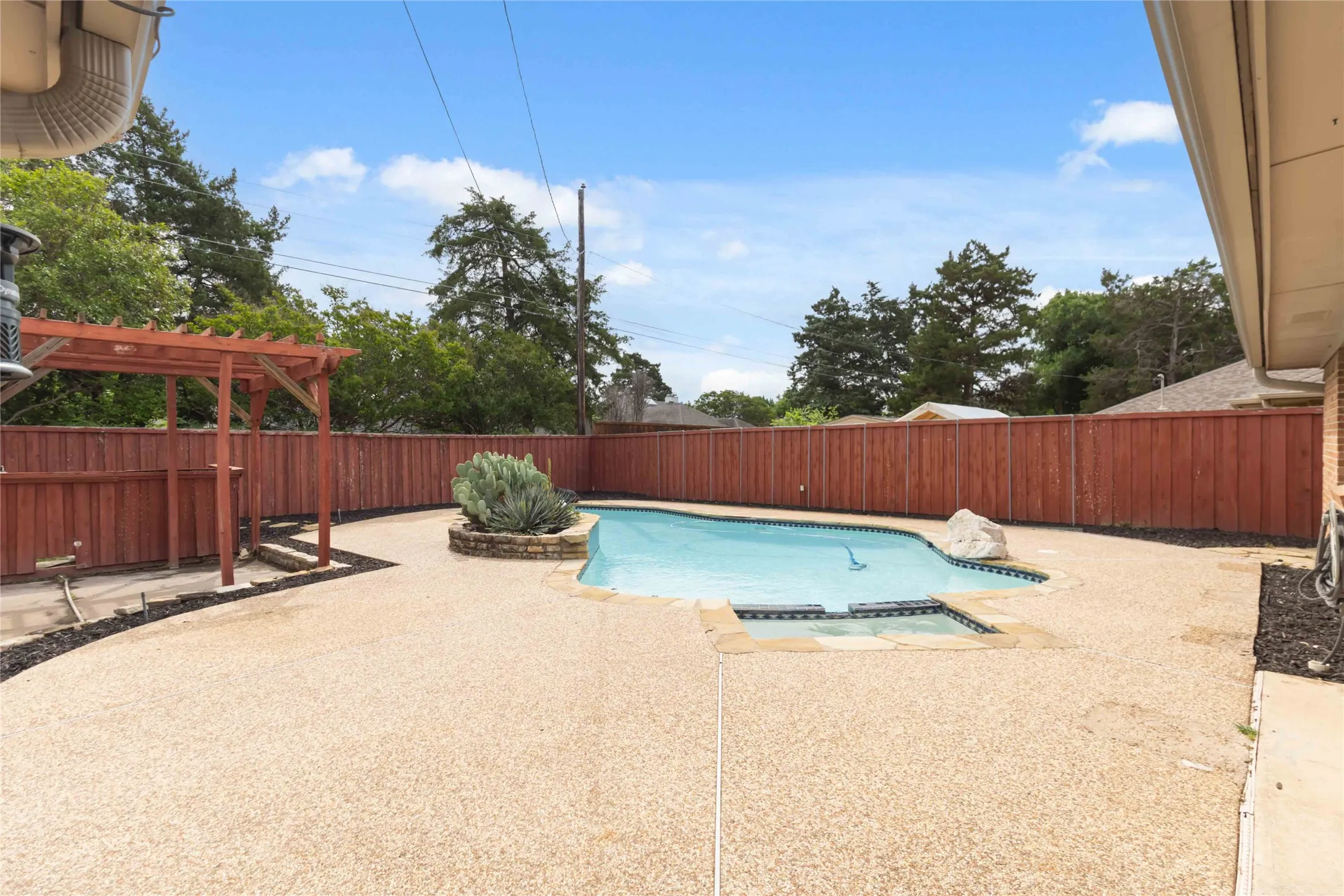 Outdoor living area at 200 Sunny Crest Dr, Murphy TX in Timbers 3 featuring in-ground pool and spacious patio.