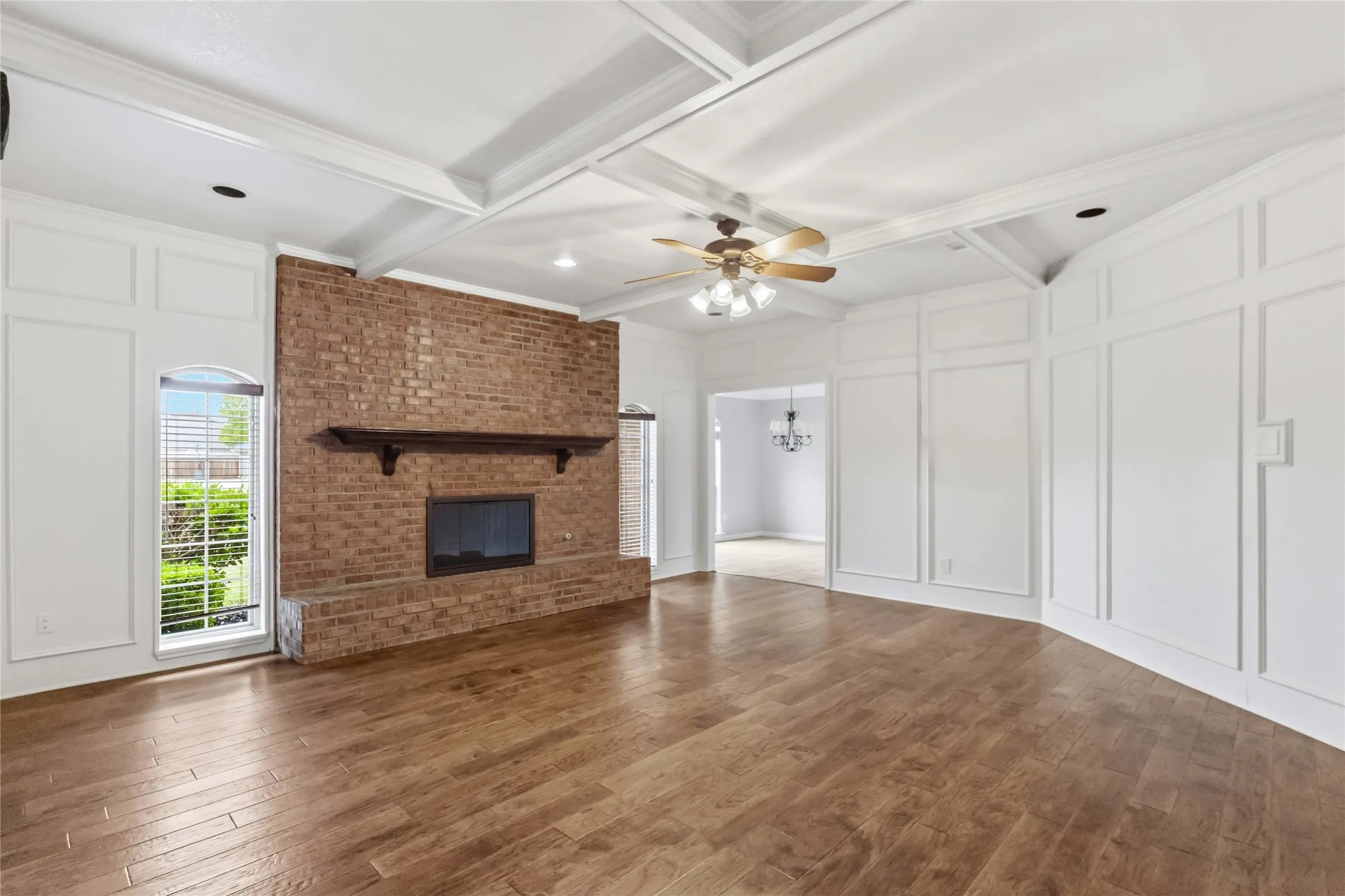 Large family room at 200 Sunny Crest Dr, Murphy TX in Timbers 3 with wood floors and a statement brick fireplace.