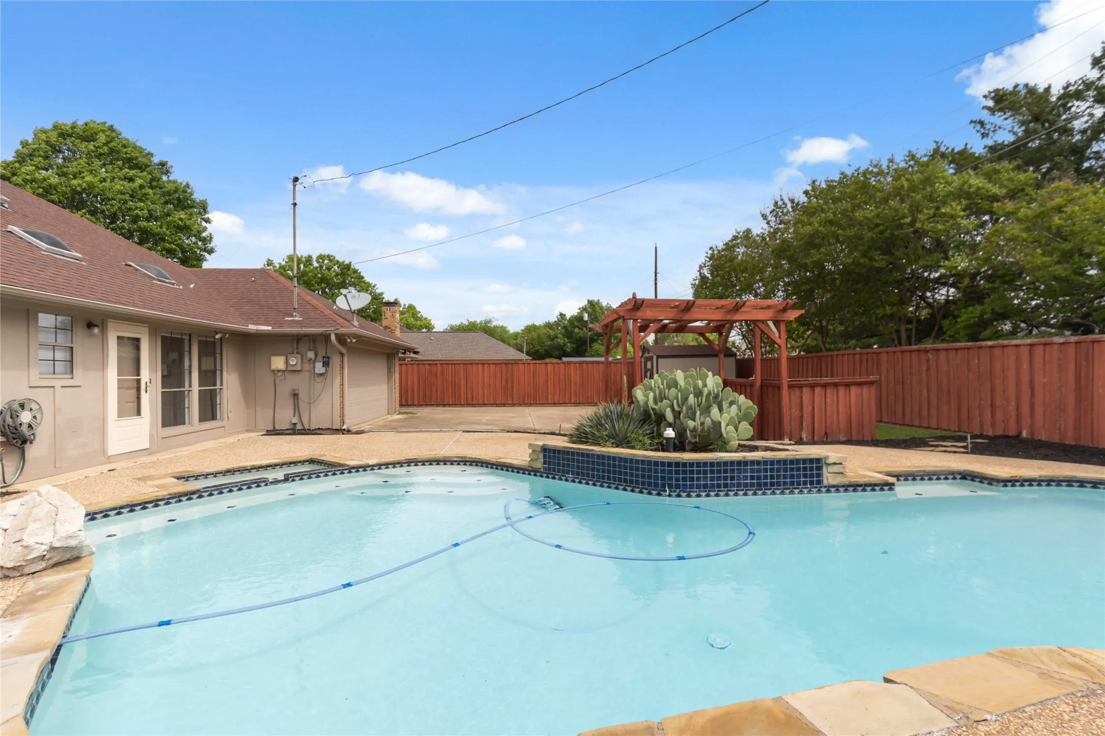 Outdoor living area at 200 Sunny Crest Dr, Murphy TX in Timbers 3 featuring in-ground pool and spacious patio.