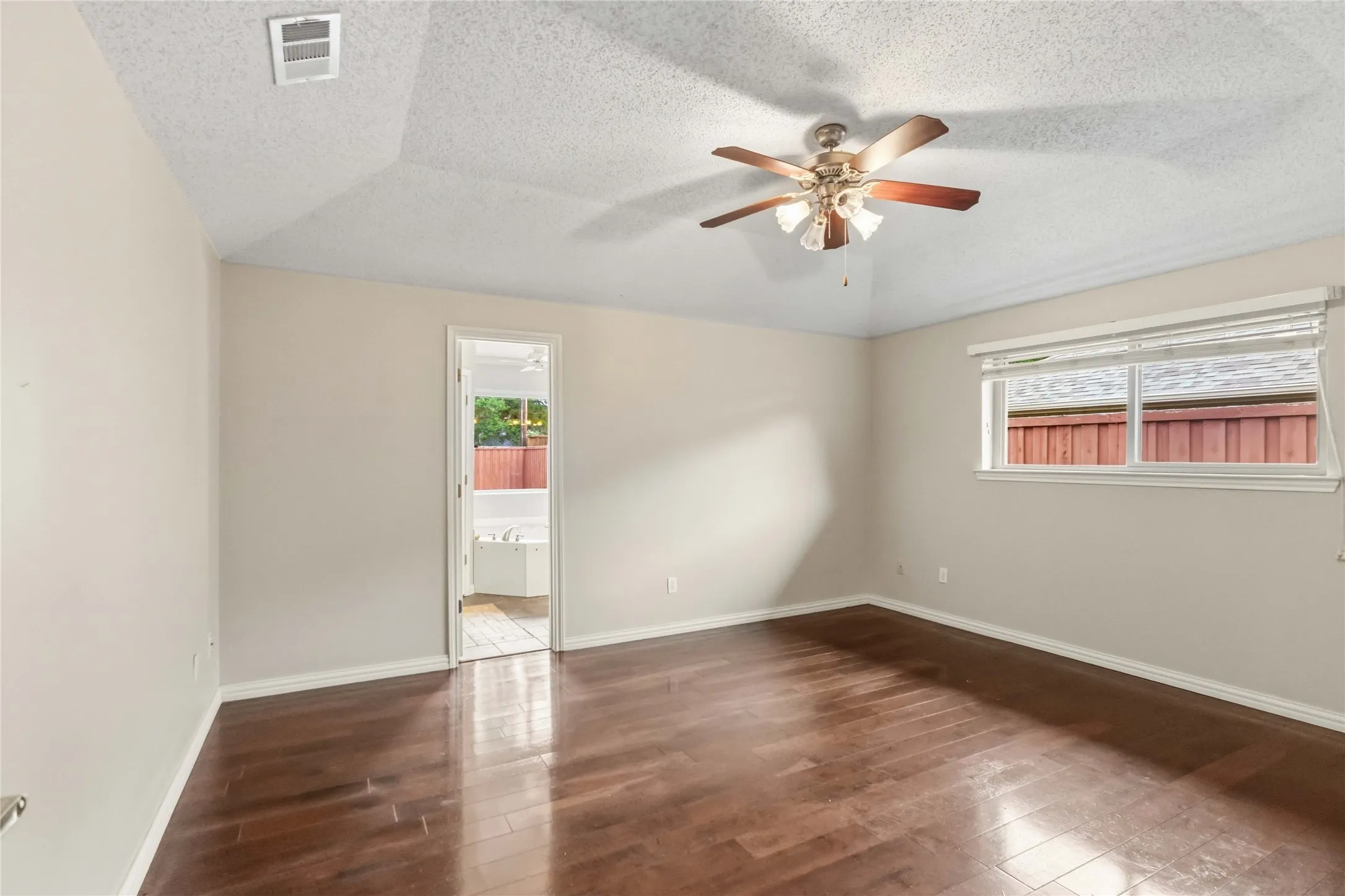 Bedroom at 200 Sunny Crest Dr, Murphy TX in the Timbers 3 community with wood flooring, ceiling fan, and neutral tones.