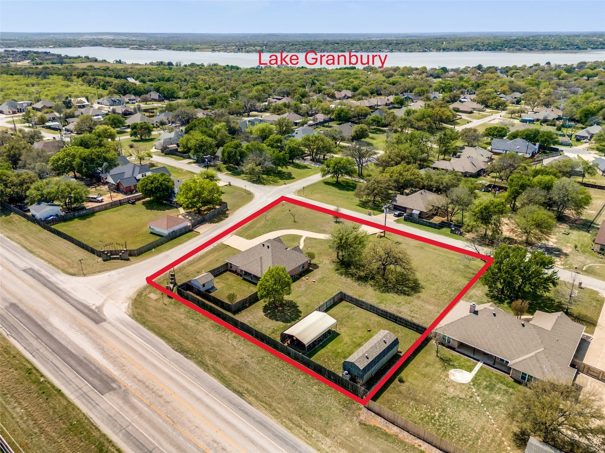 Aerial view of residential area featuring property boundaries highlighted and a nearby body of water