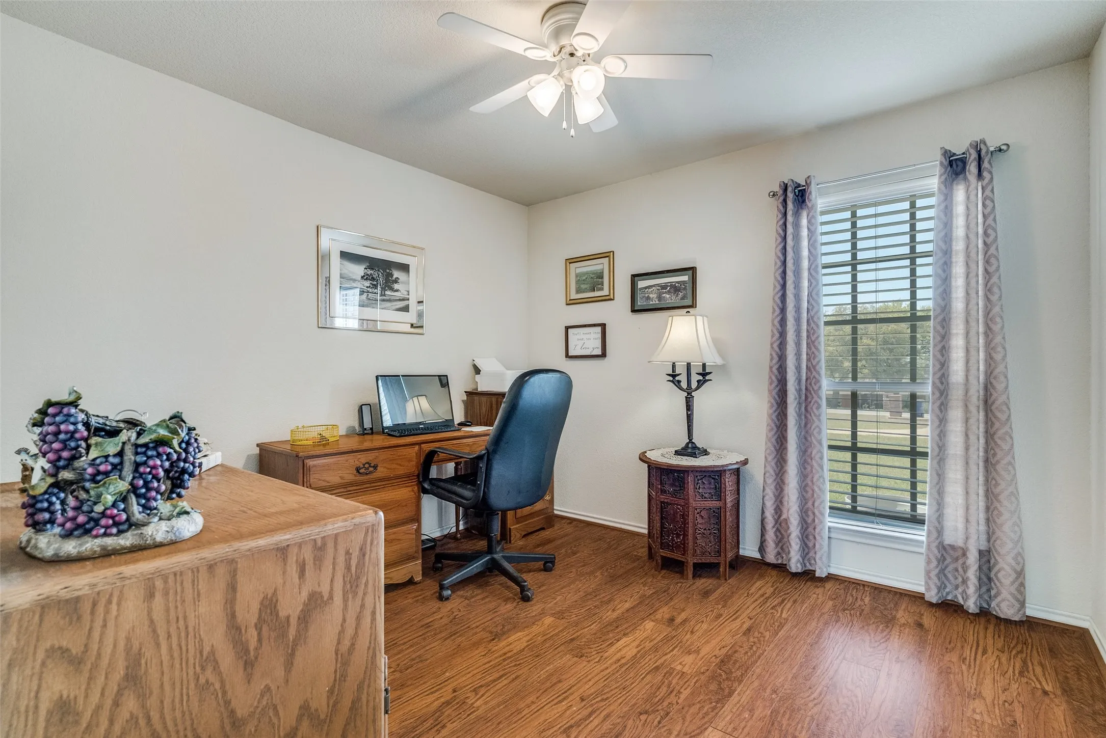 Office space featuring dark wood-type flooring and a ceiling fan