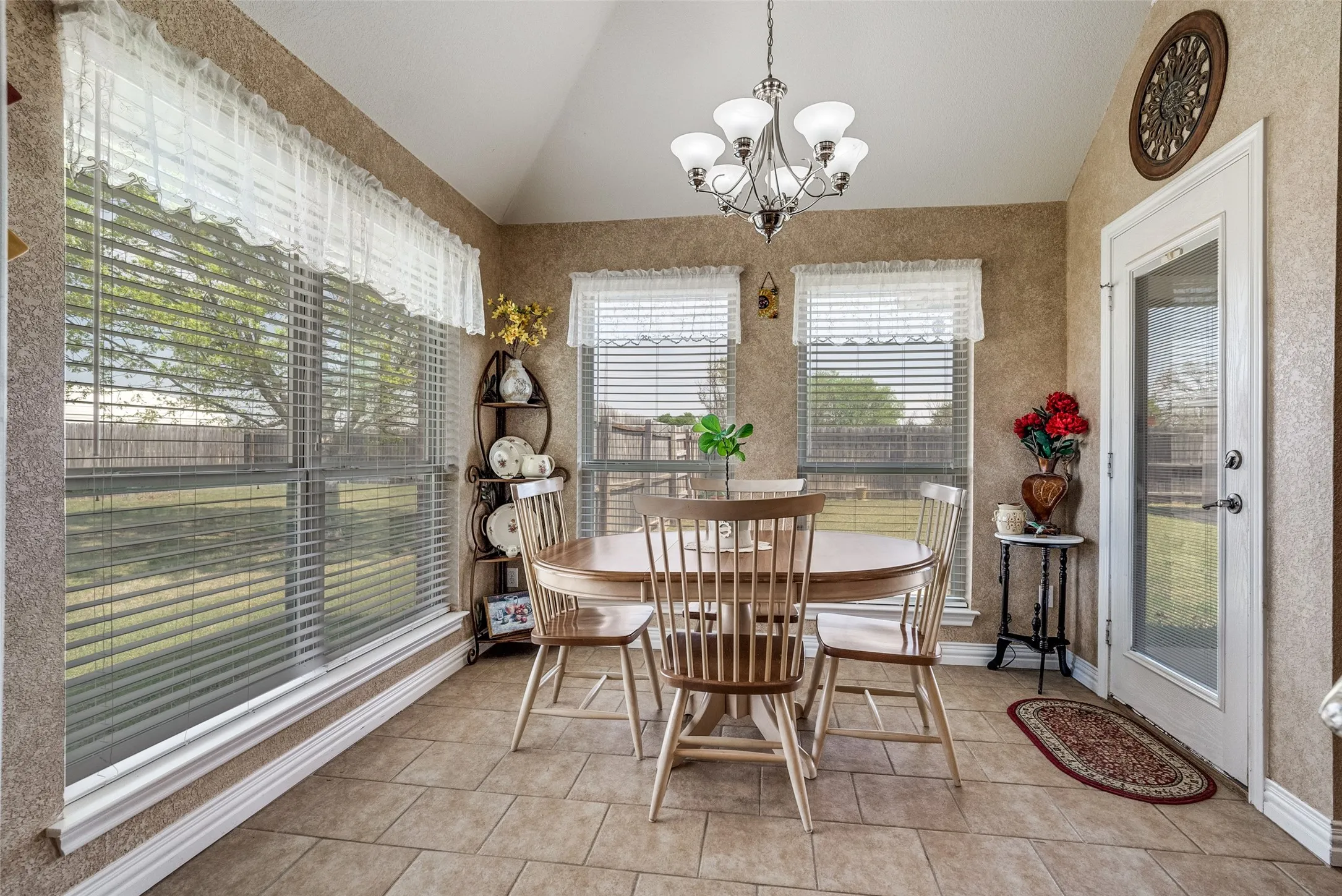 Dining space with vaulted ceiling, a chandelier, and light tile patterned flooring