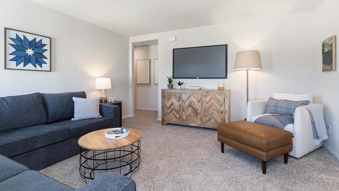 Carpeted living area with textured walls and a recessed doorway