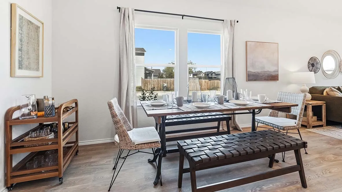 Expansive windows with dark trim, wood-finish flooring, and white walls throughout