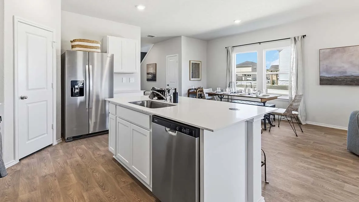 Kitchen featuring a large island with white cabinetry and an undermount sink, stainless steel appliances, and wood-finish flooring