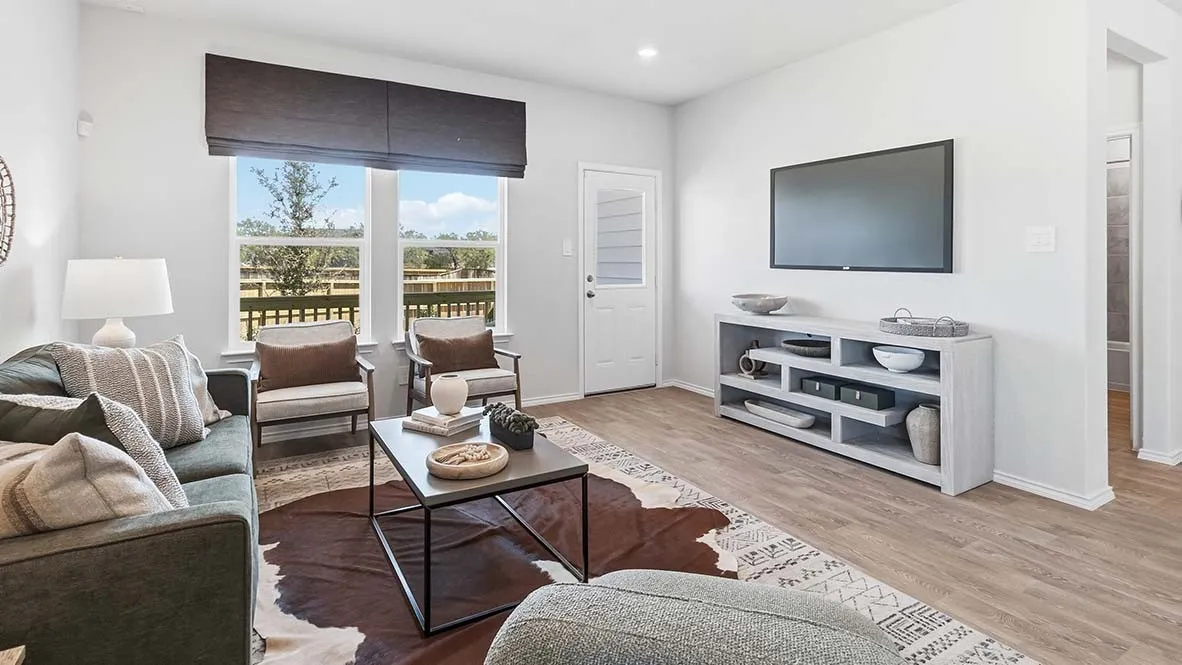 Spacious living area featuring wood-finish flooring, large windows, recessed lighting, and a neutral color palette