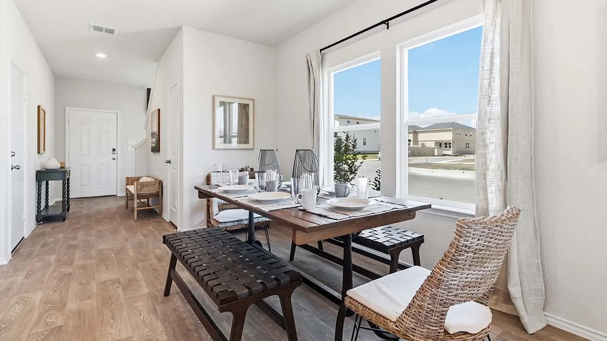 Wood-finish flooring, white paneled door, three single-hung windows, and recessed lighting