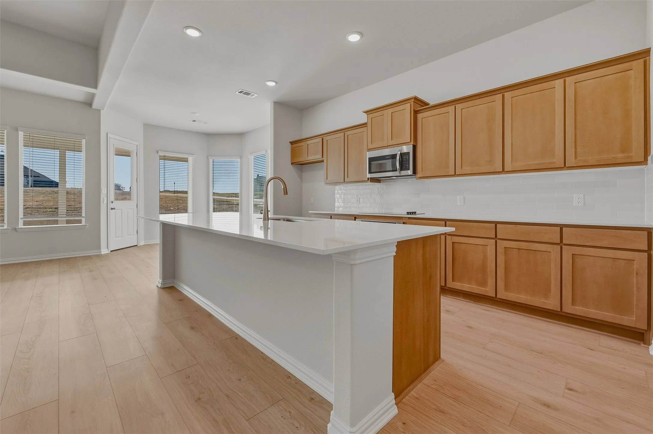 Central kitchen island with a single-basin sink and a gooseneck faucet