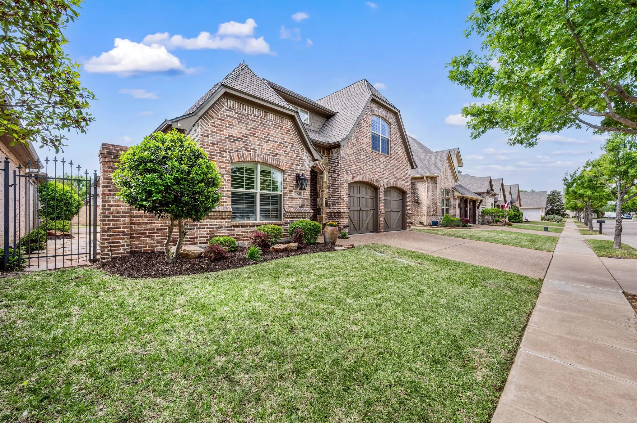 Side angle view showcasing manicured lawn, mature trees, and attractive neighborhood streetscape.