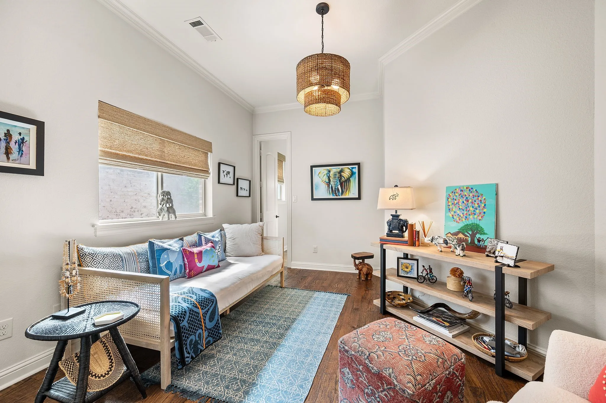 Bright secondary bedroom with wood flooring and stylish lighting