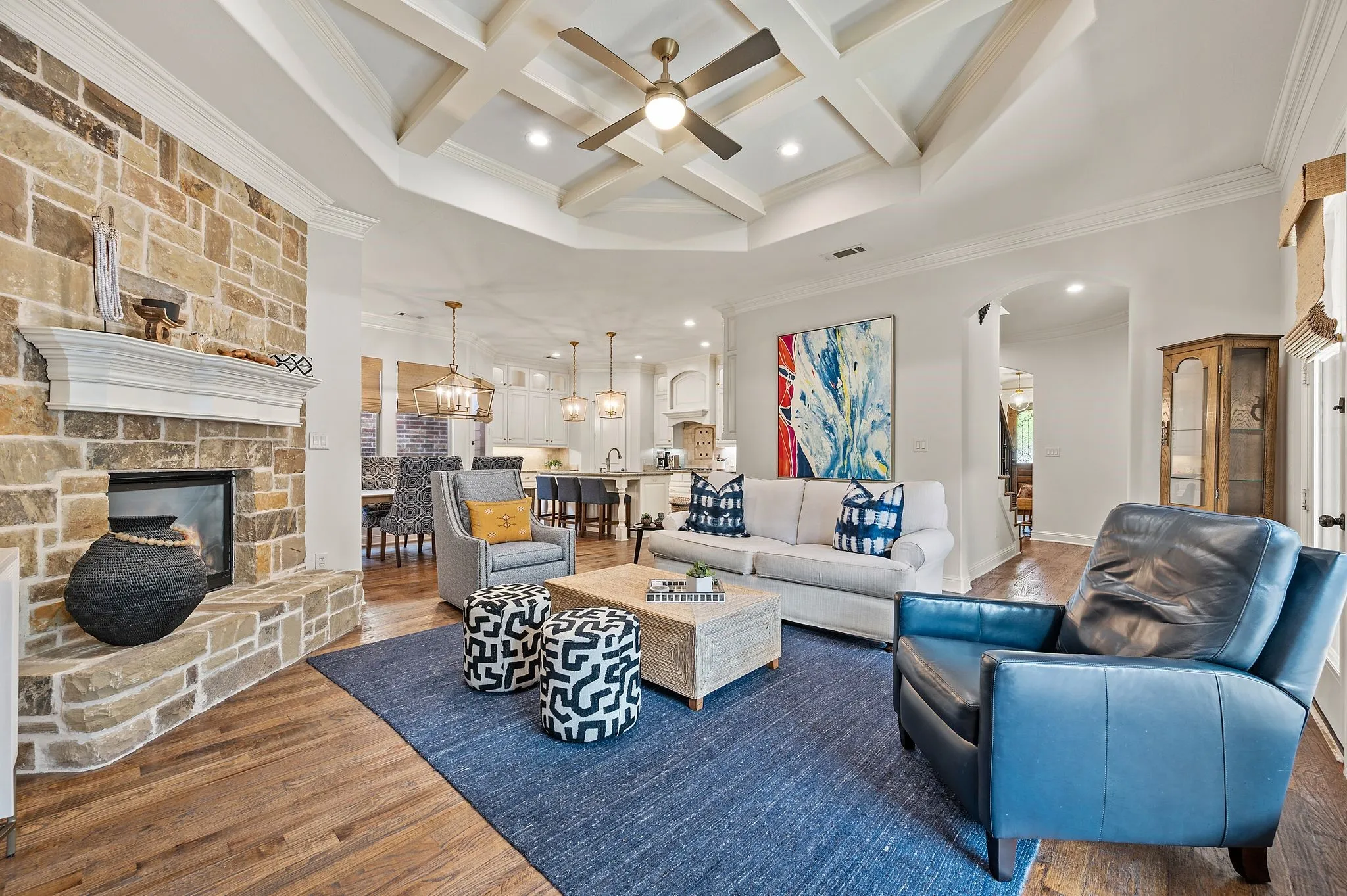 Expansive living space highlighting architectural ceiling detail and cozy fireplace.