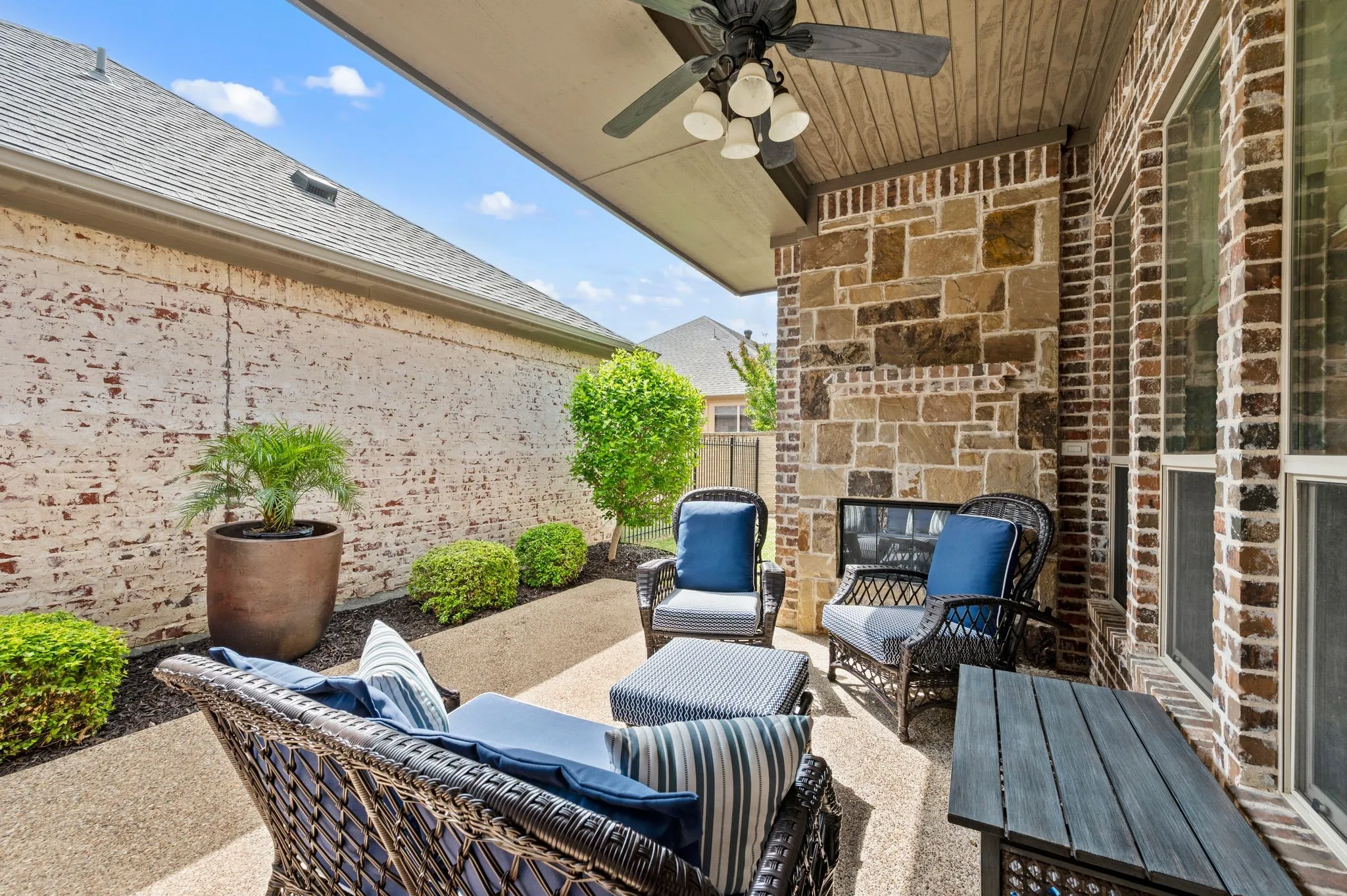 Covered back patio with ceiling fan and seating area, perfect for outdoor entertaining