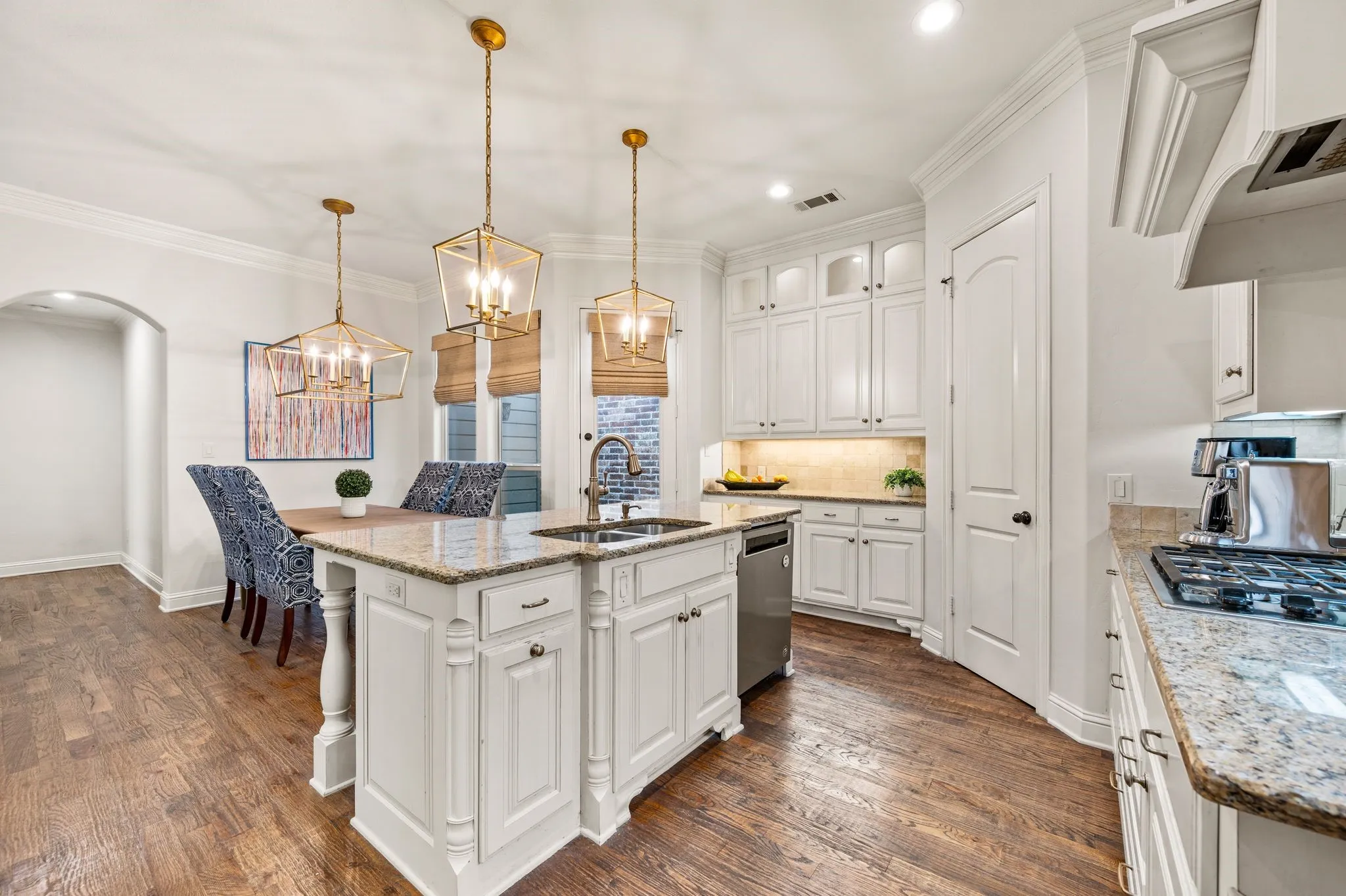 Spacious kitchen with breakfast bar seating and open view to dining and living areas.