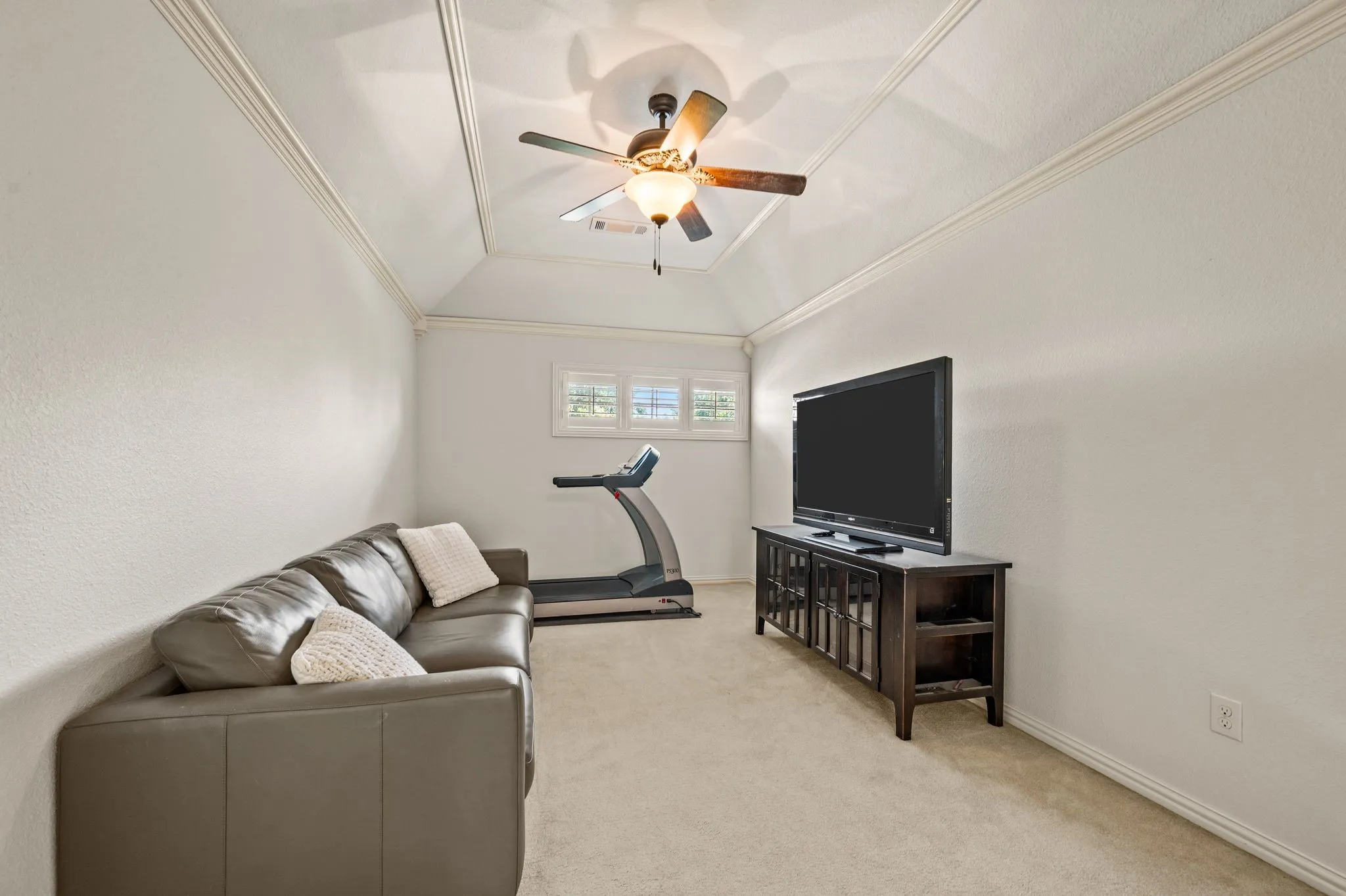 Cozy upstairs living area or game room with vaulted ceiling and ceiling fan