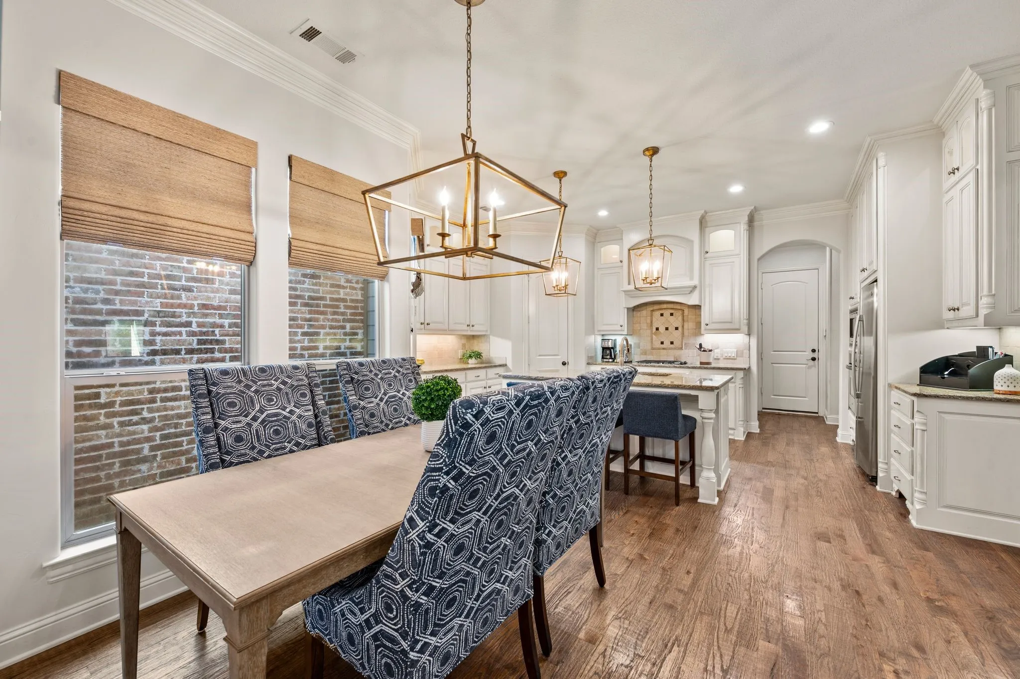Dining area with designer lighting, large windows, and easy access to kitchen.