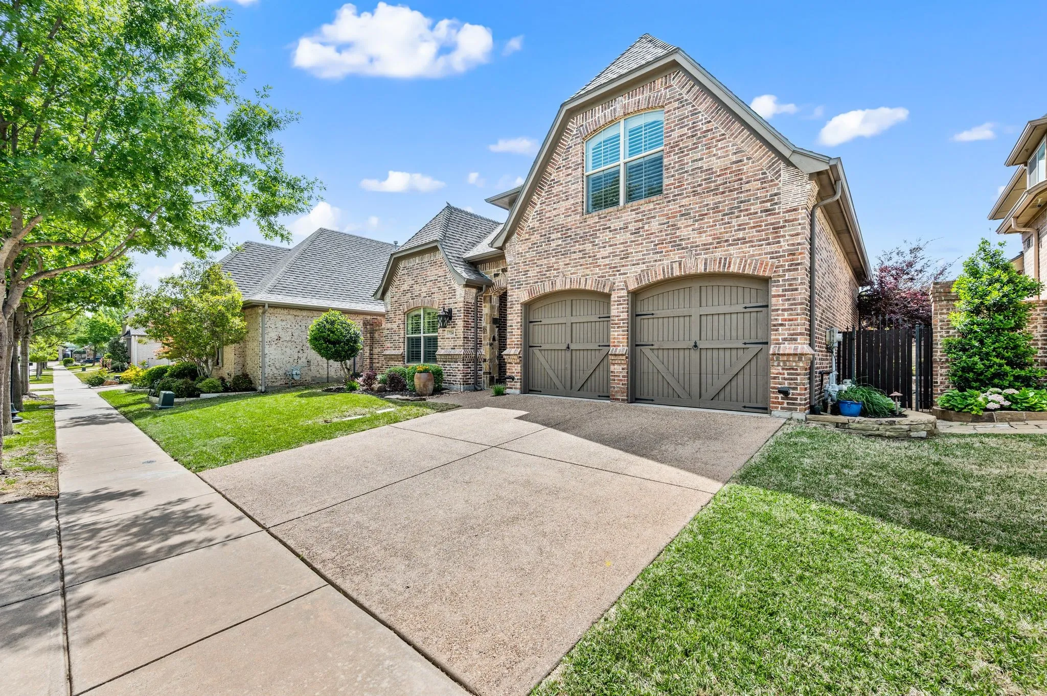 Front facing garage with carriage-style doors and well-maintained landscaping.