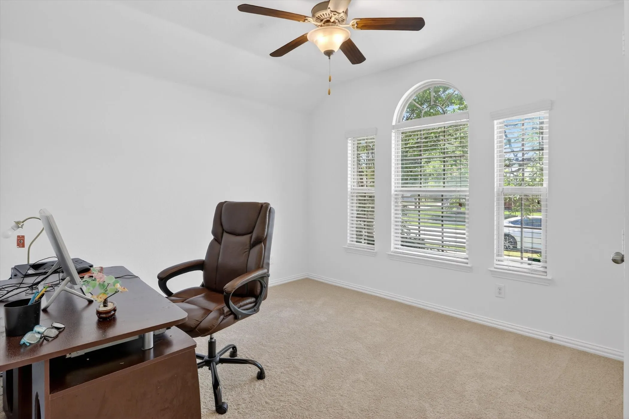 Vaulted ceiling room with an arched window and two rectangular windows, all featuring white blinds