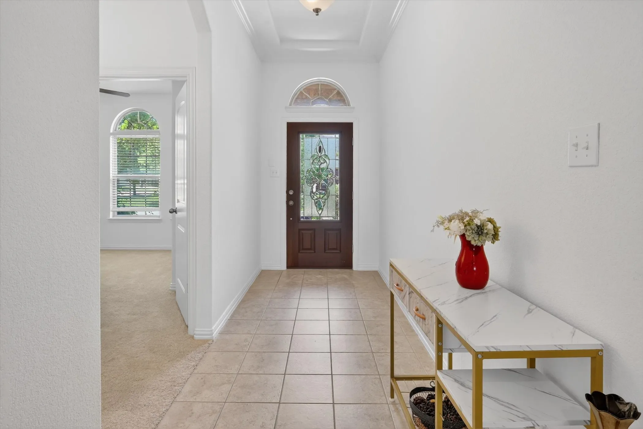 Entryway featuring tiled flooring, a decorative front door with an arched transom, and a coffered ceiling