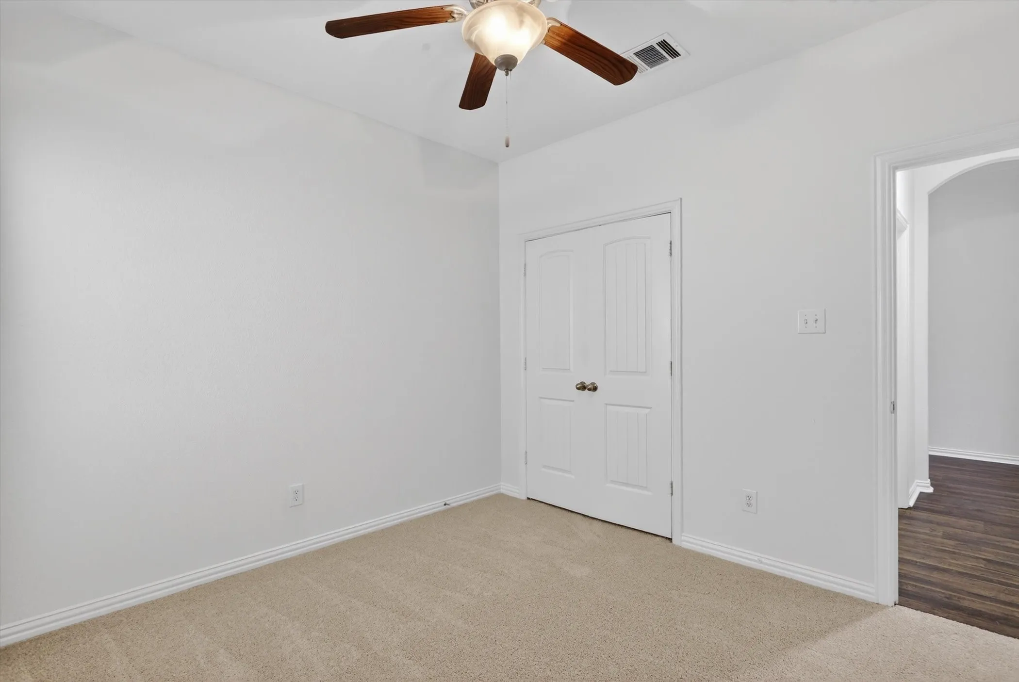 Room featuring neutral carpeting, white walls, and a ceiling fan with integrated lighting