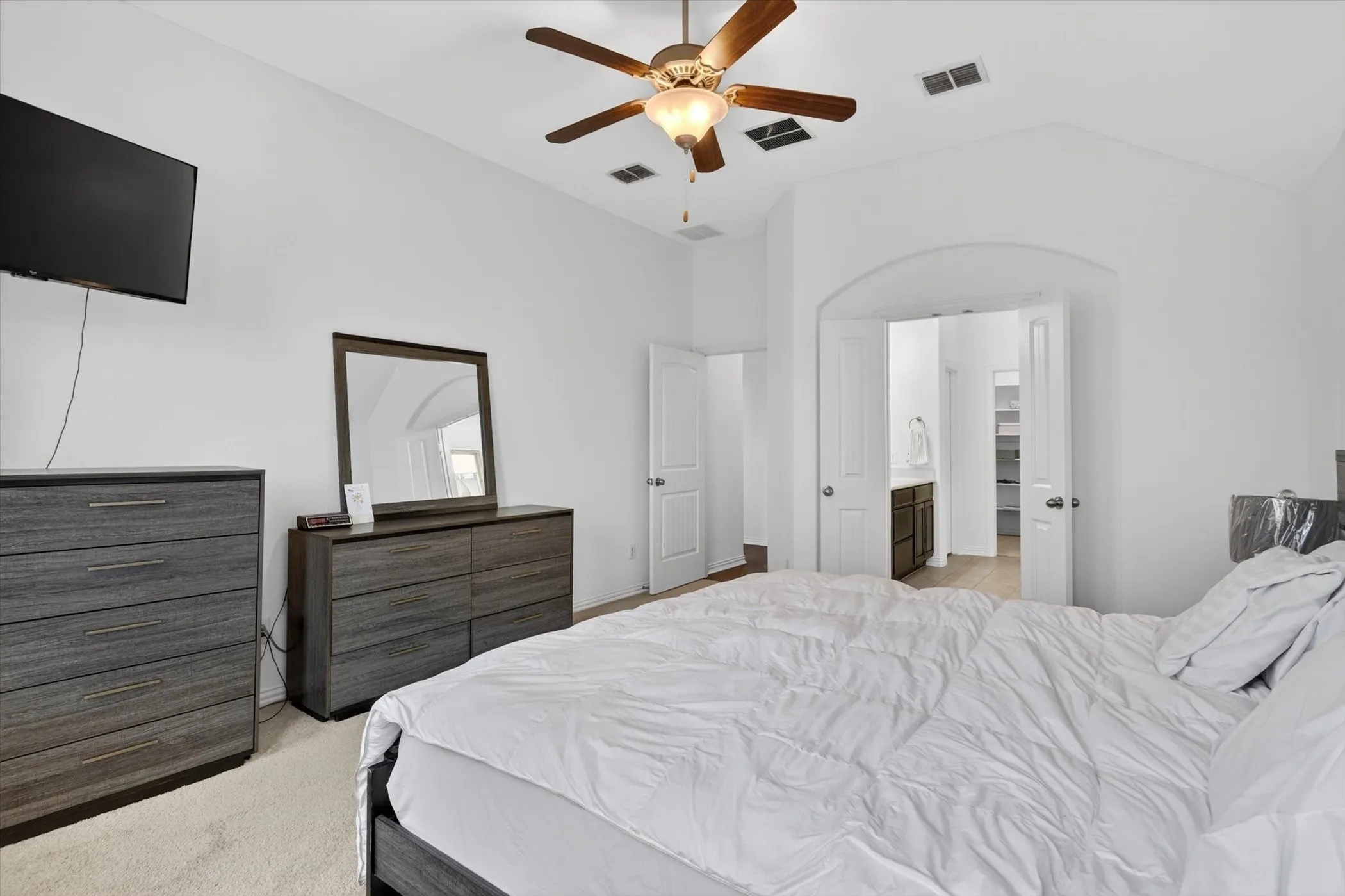 Vaulted ceiling bedroom with a wood-finish ceiling fan and recessed lighting