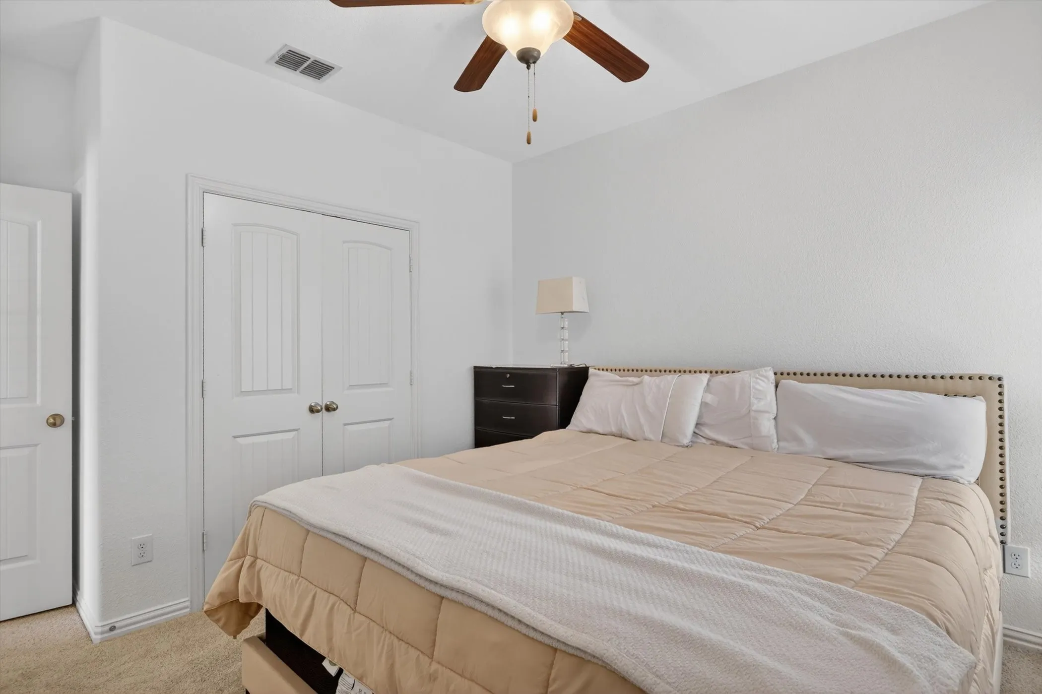 Carpeted room featuring a ceiling fan with integrated lighting, white walls, and white trim