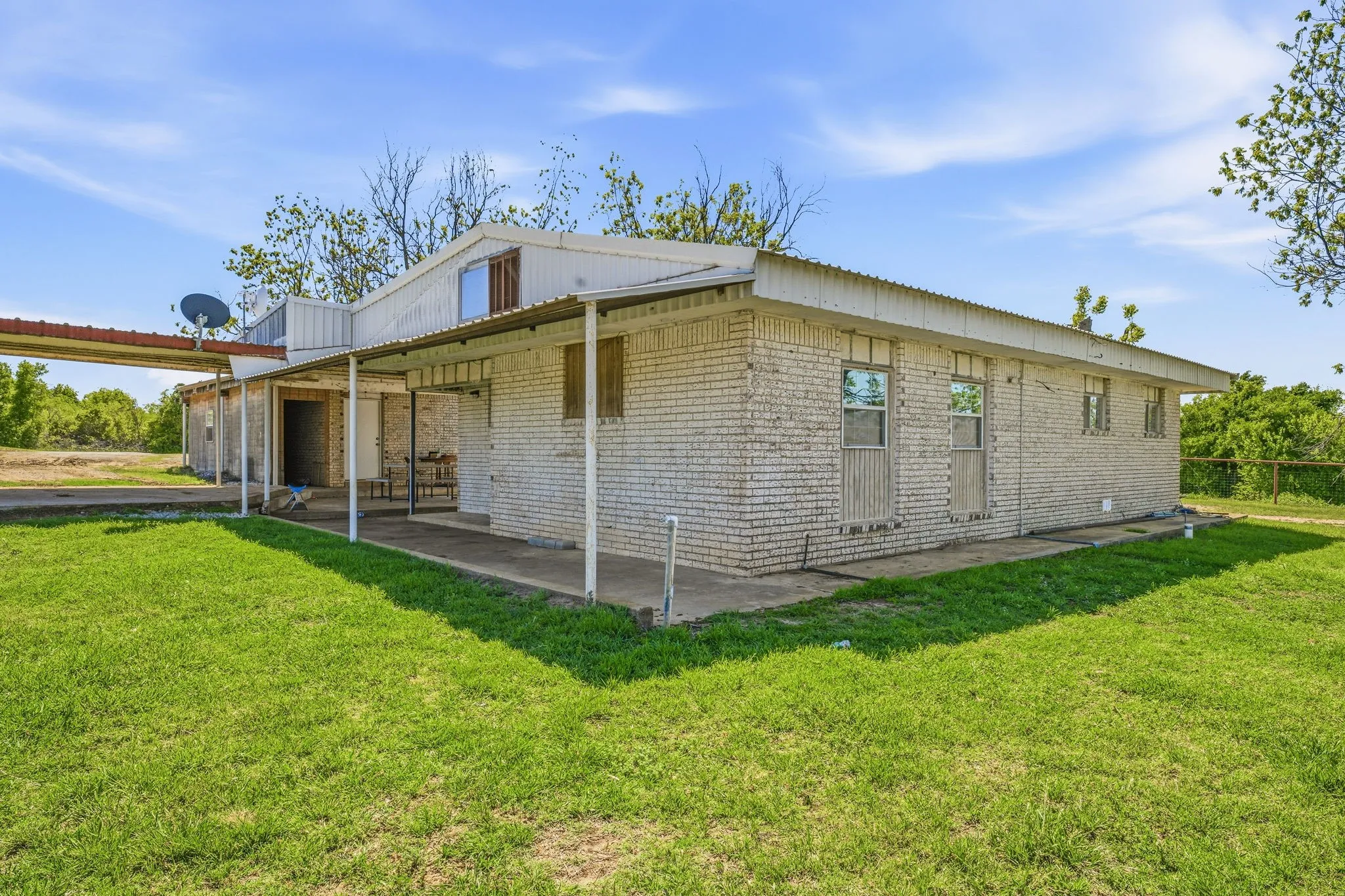 View of side of property featuring brick siding and a lawn