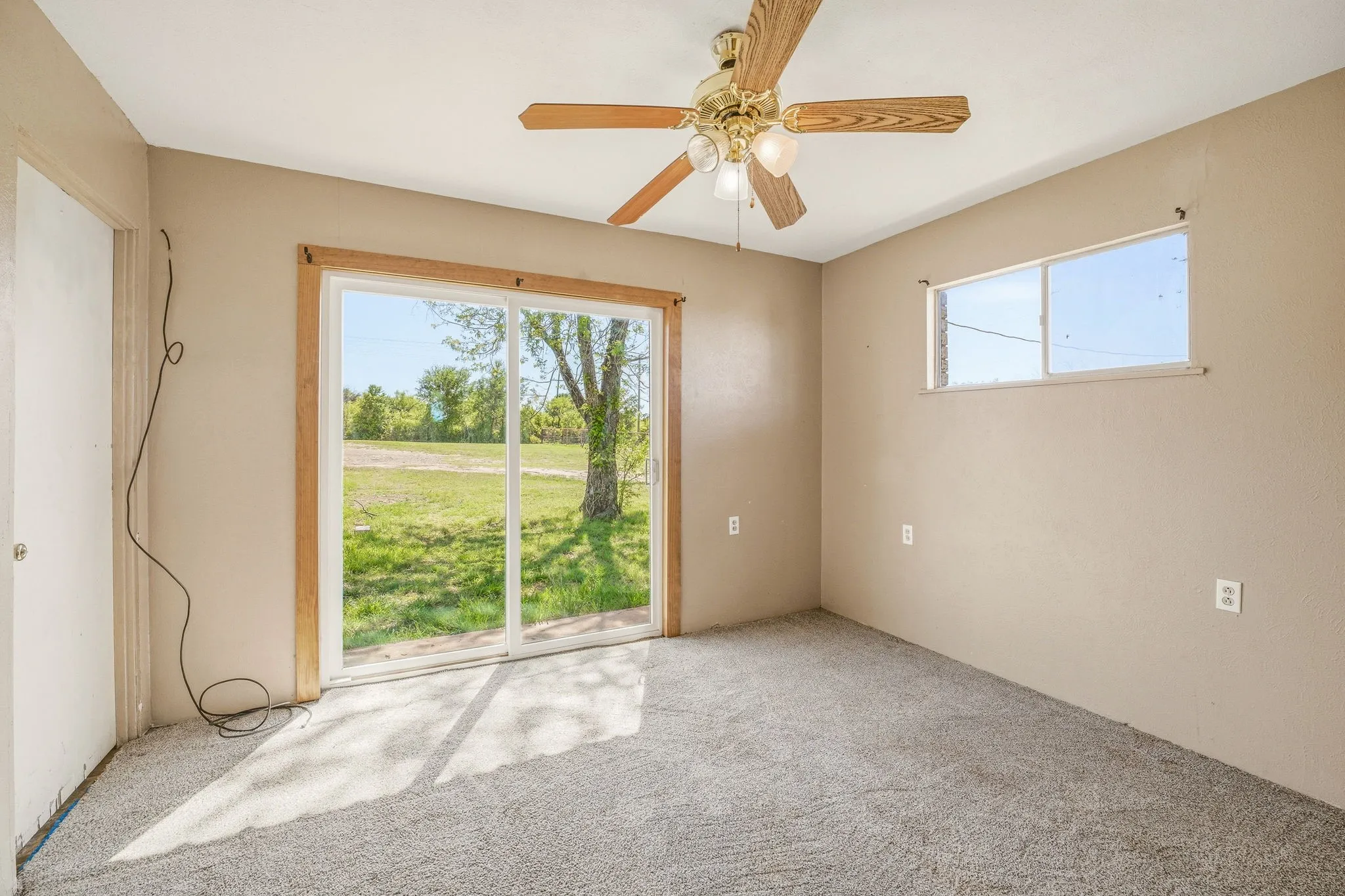 Carpeted empty room featuring a ceiling fan