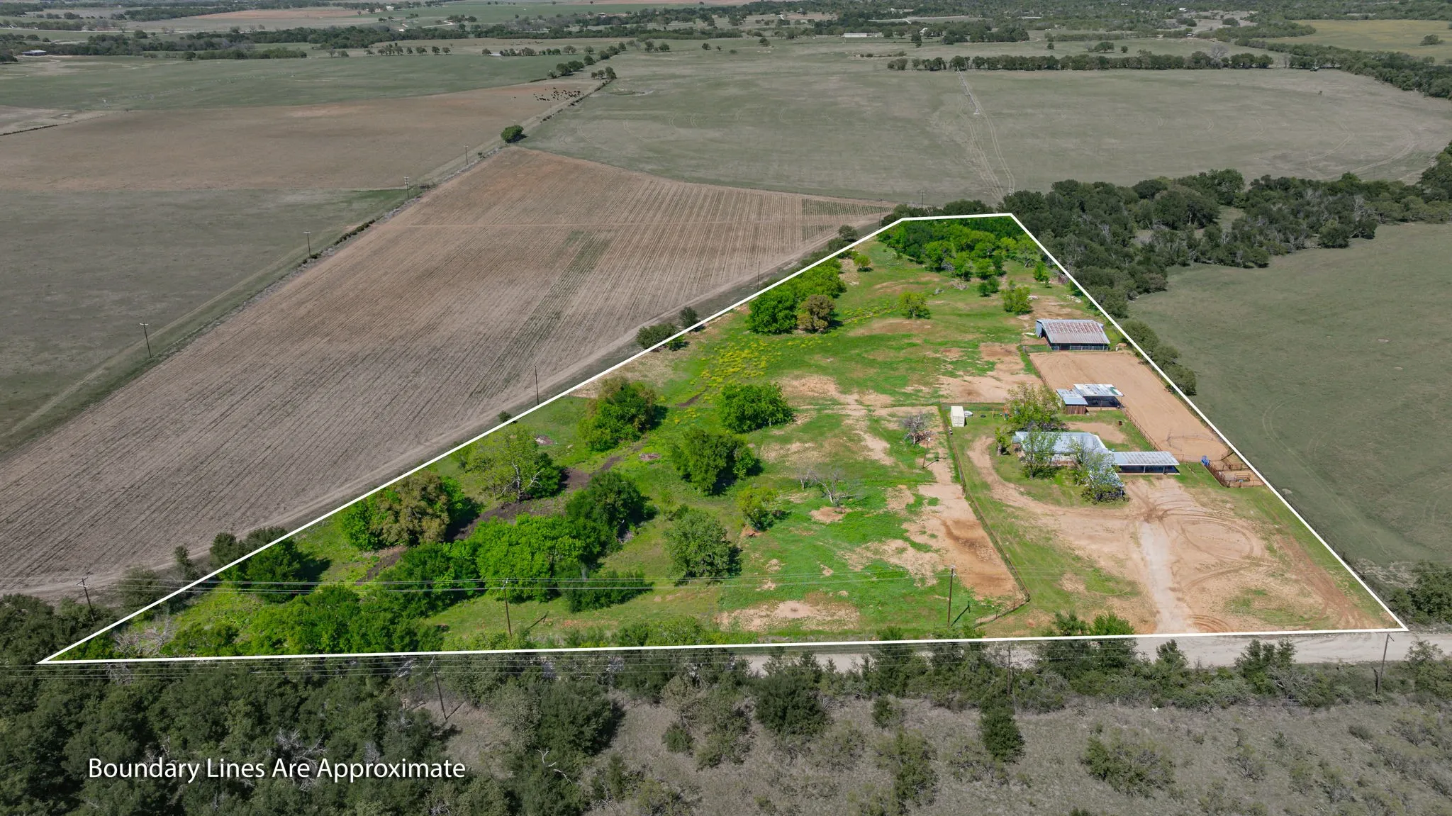 Overview of rural landscape featuring property parcel outlined and rows of crops