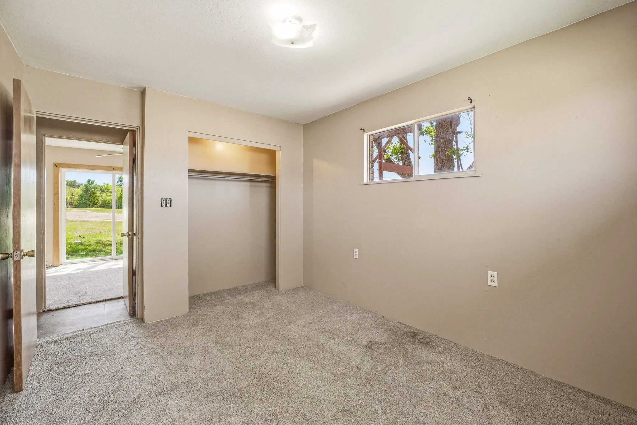 Unfurnished bedroom with light colored carpet and a closet