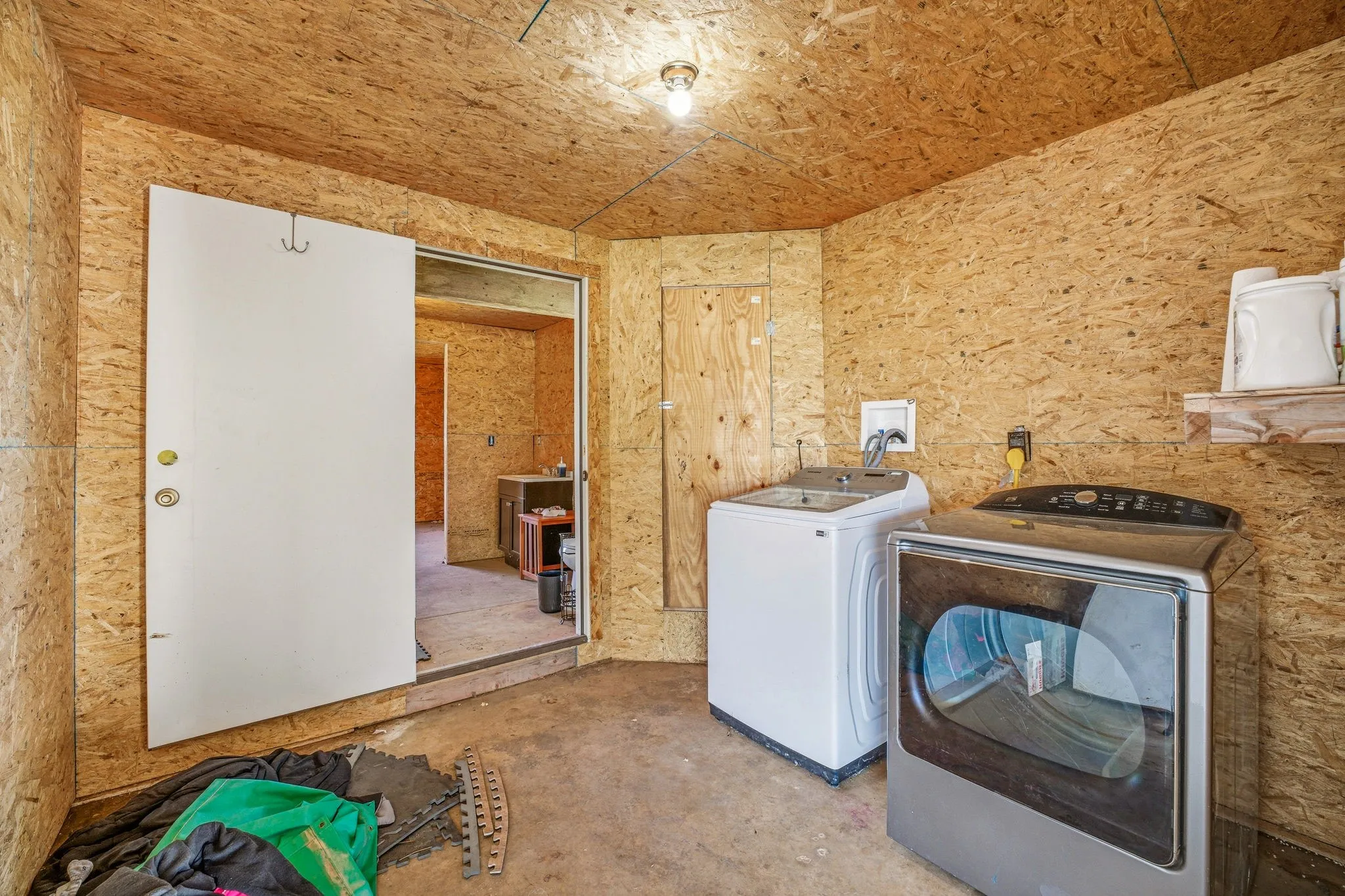 Laundry room featuring washer and dryer and unfinished concrete floors