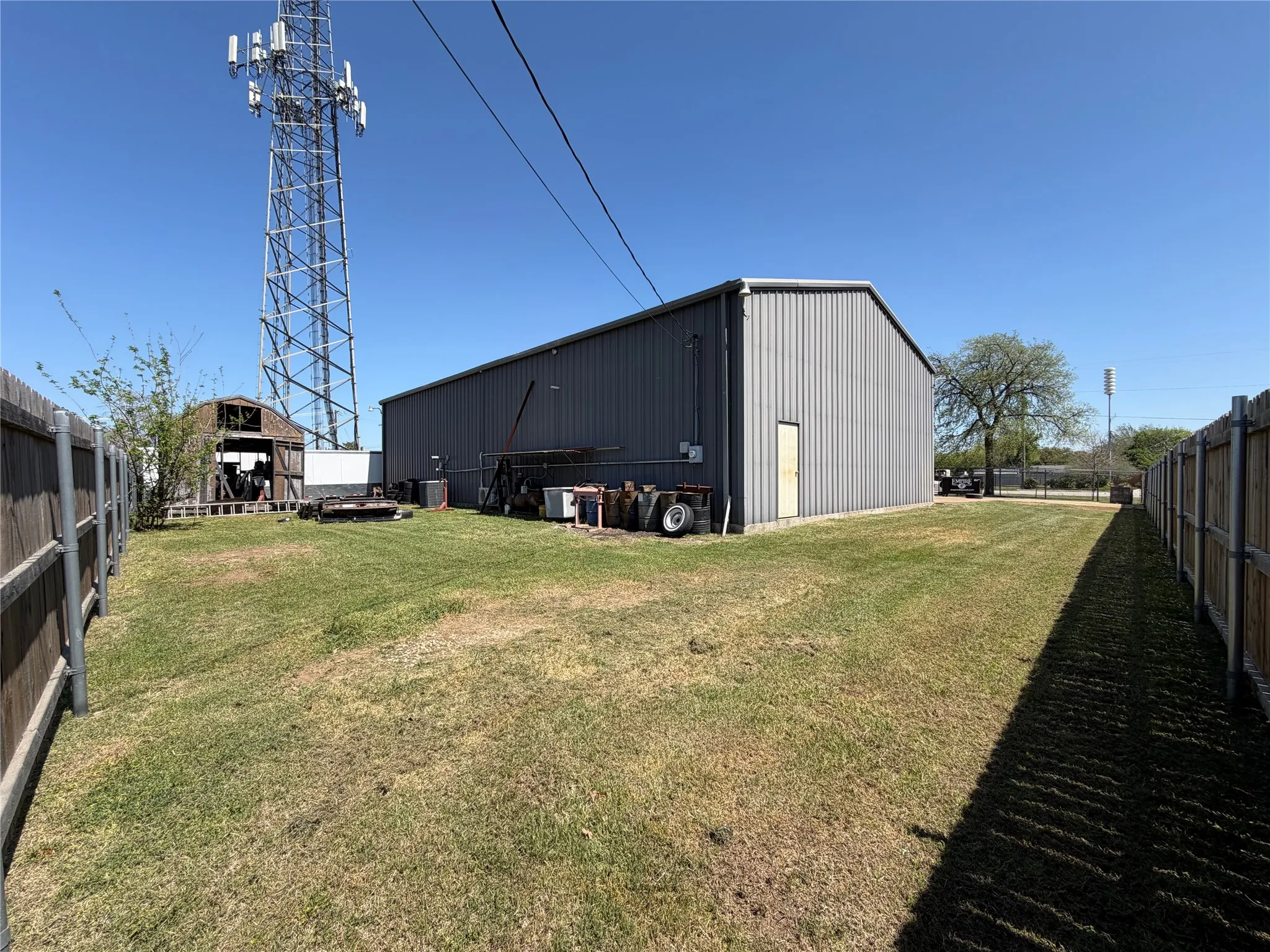 Fenced yard with a pole building and an outdoor structure