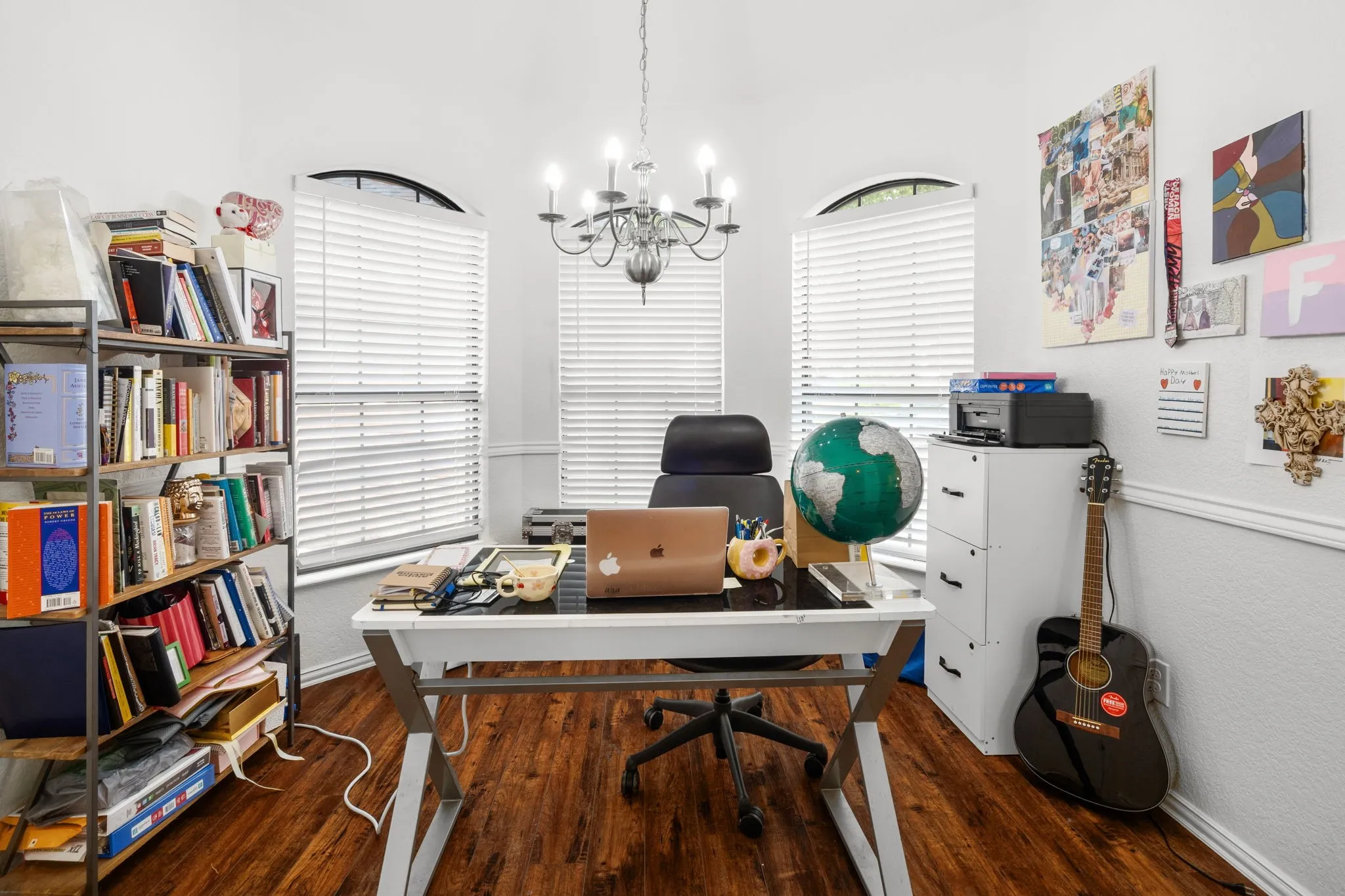 Home office with suspended lighting and dark wood-style flooring
