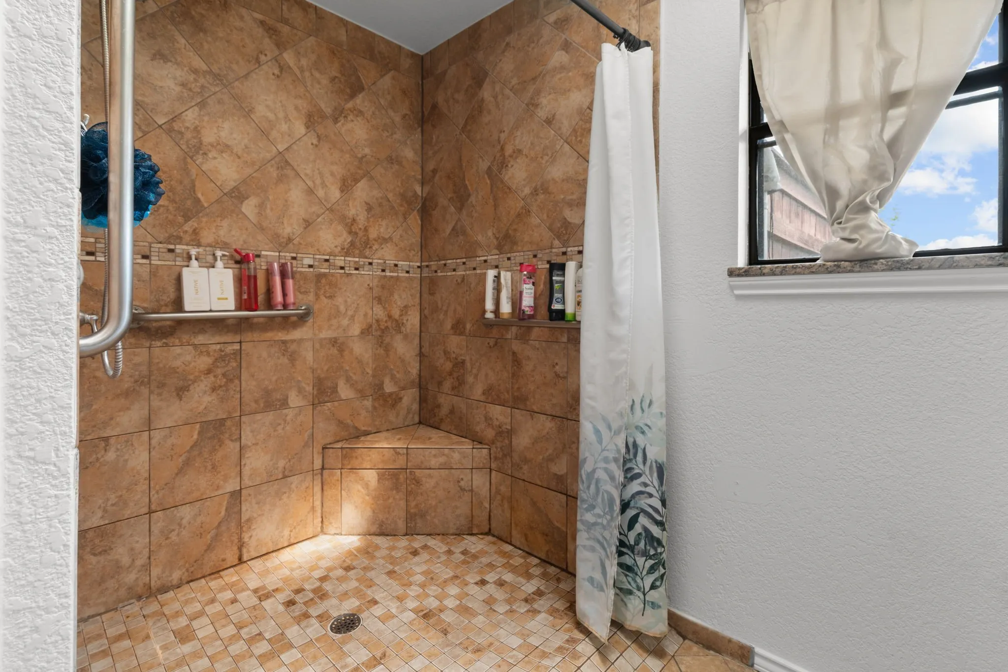 Full bath featuring a stall shower and a textured wall
