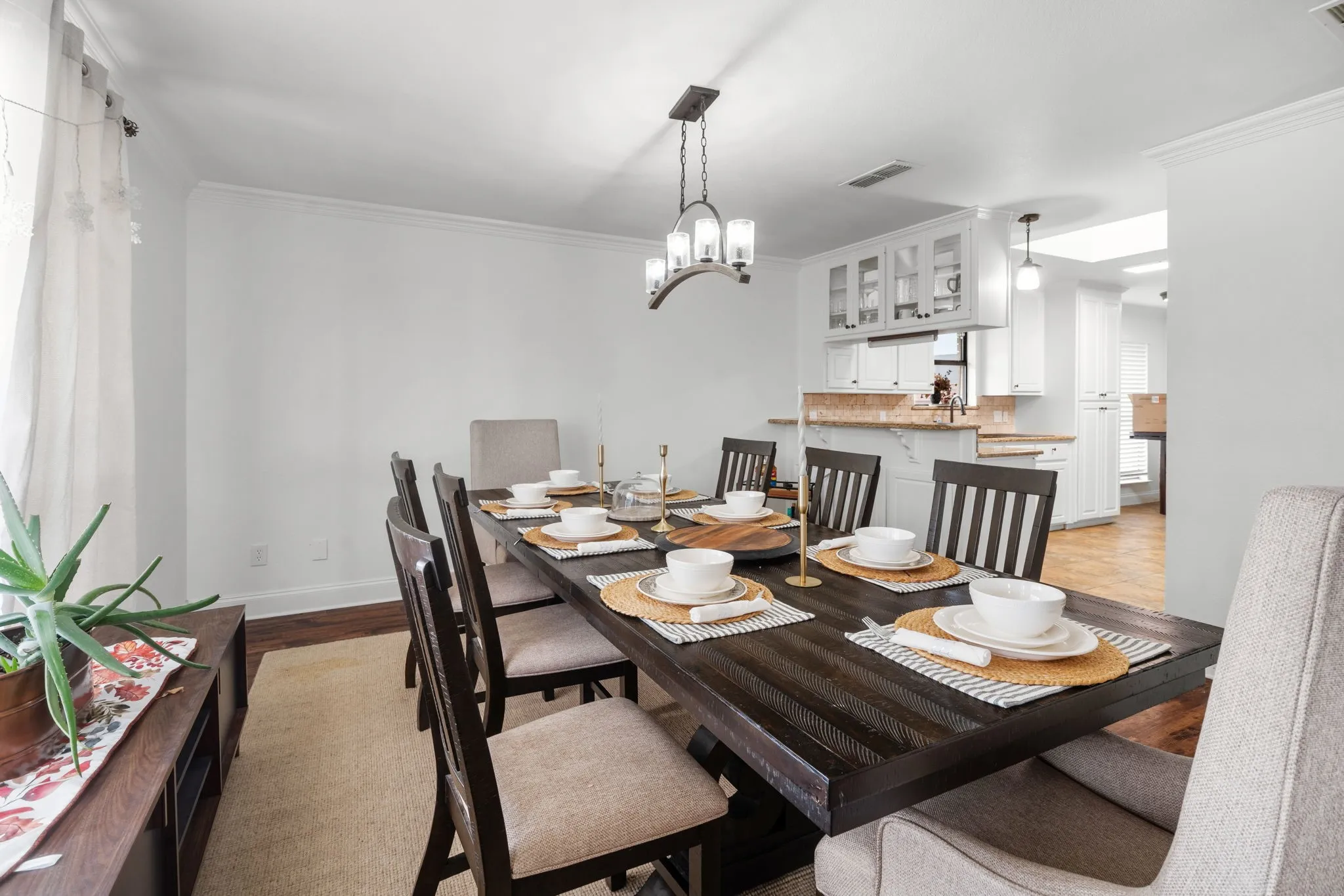 Dining room with crown molding, light wood finished floors, and suspended lighting