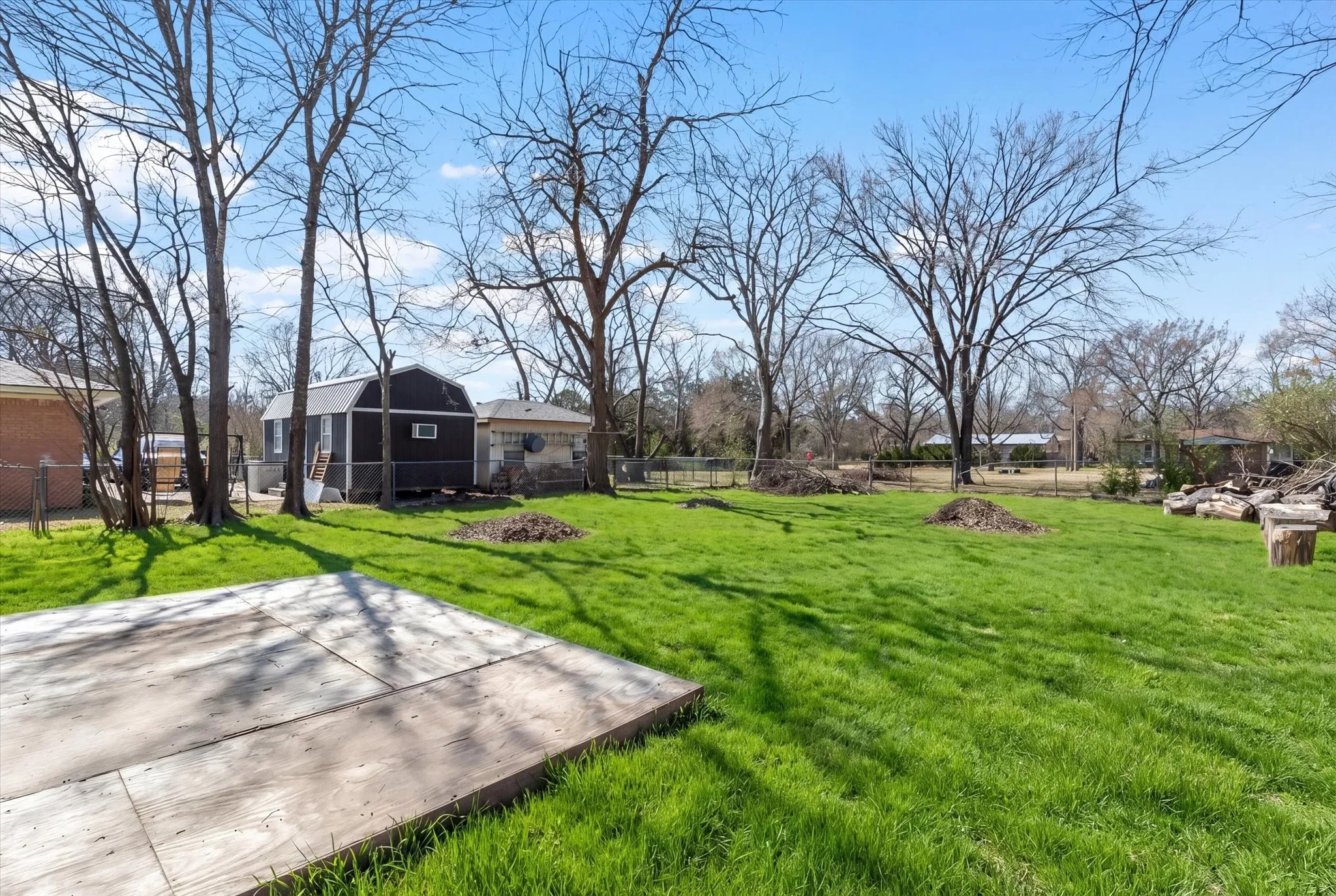 The property features an expansive lawn with mature trees and a concrete pad
